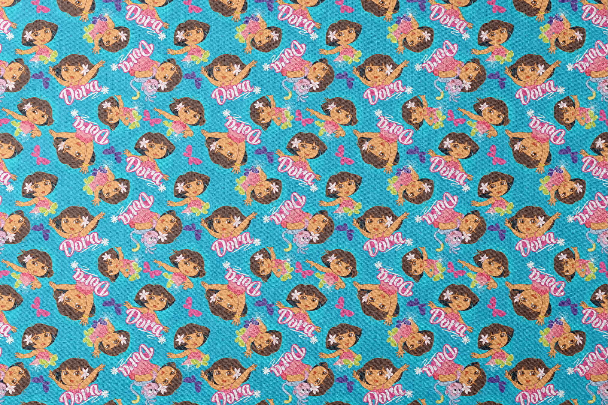 Bright blue pattern with cartoon character Dora, flowers, and "Dora" text repeated throughout designs flat mockup