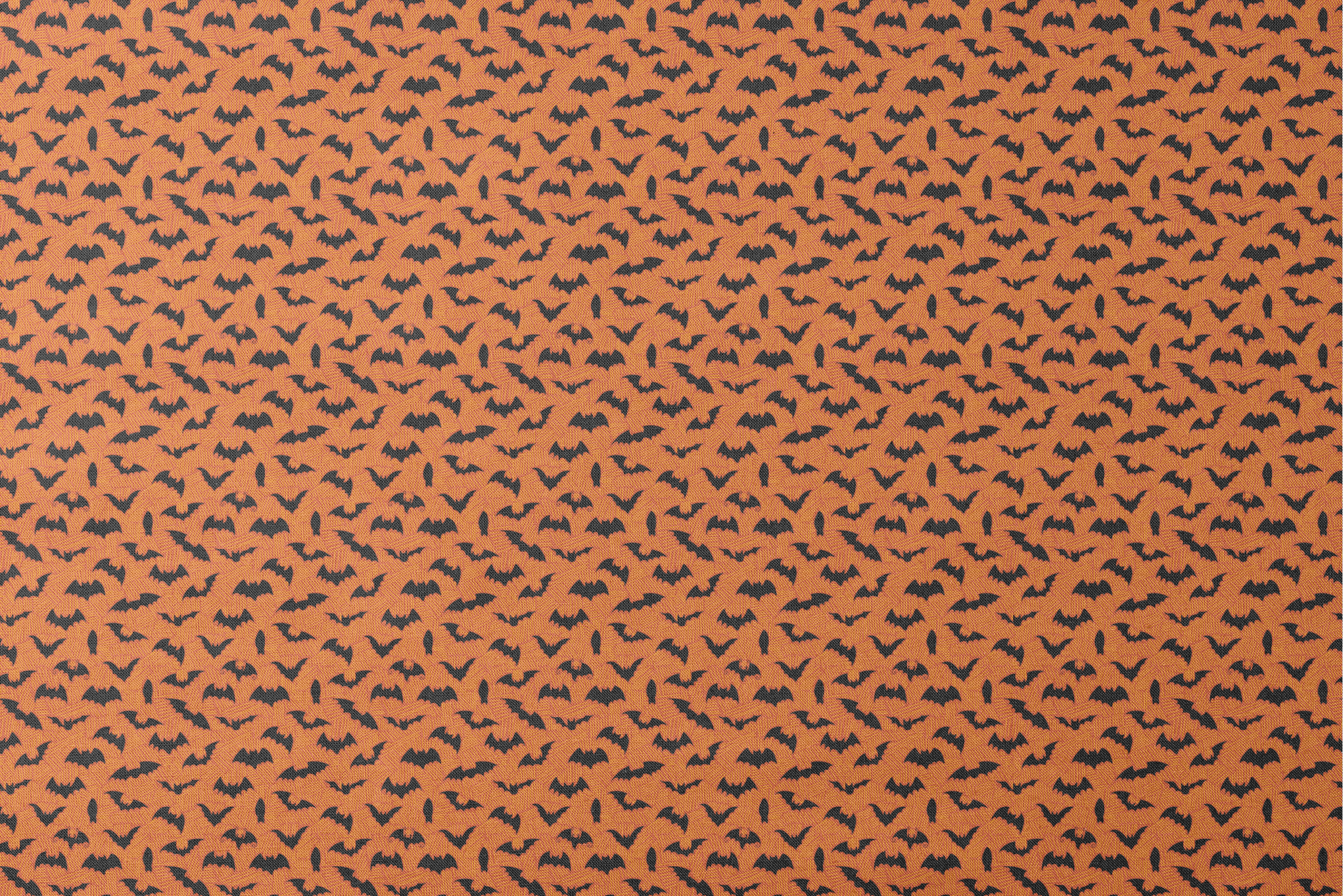 Halloween pattern with black bats scattered across an orange textured background designs flat mockup
