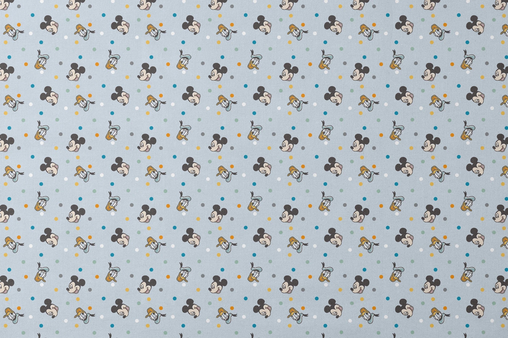 Disney character pattern with Mickey Mouse and Donald Duck heads scattered on light blue background with colorful polka dots designs flat mockup