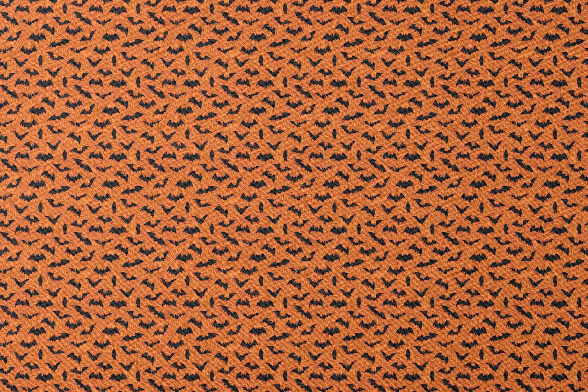 Halloween pattern with black bats scattered across an orange textured background designs flat mockup