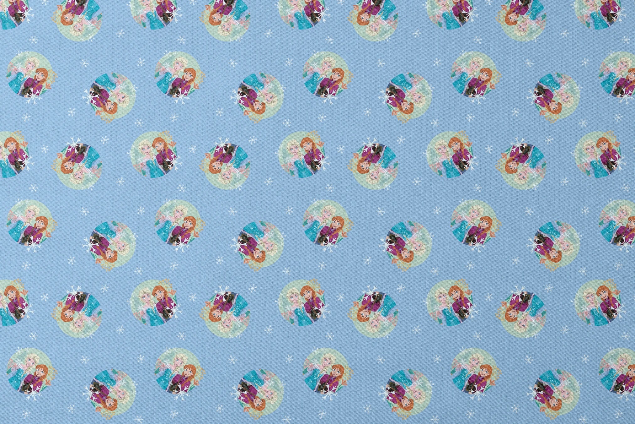 Light blue background with repeating circular motifs of "Frozen" characters and snowflakes in a decorative pattern designs flat mockup