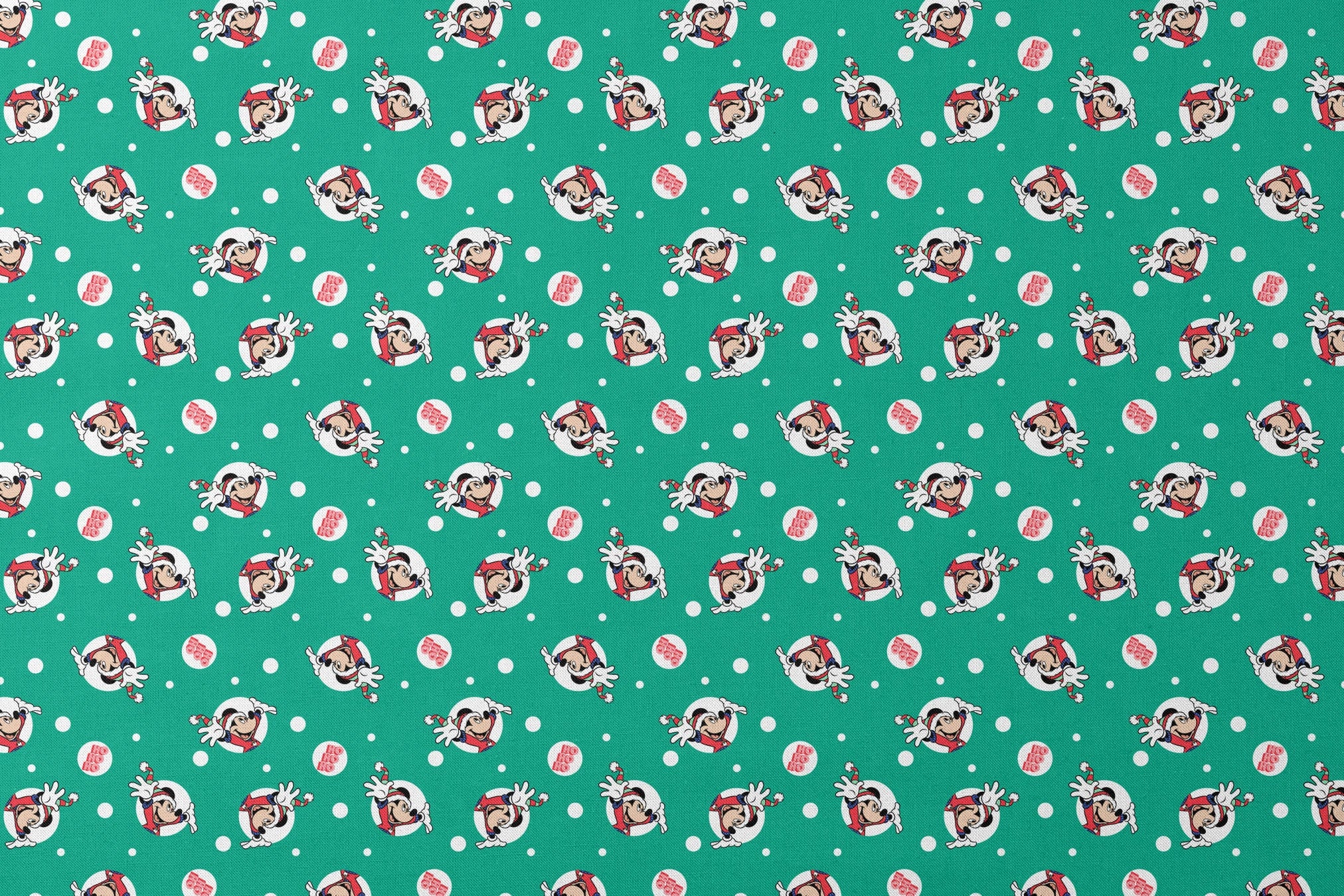 Mickey Mouse in Santa hats on green polka dot background with "Ho Ho Ho" text designs flat mockup