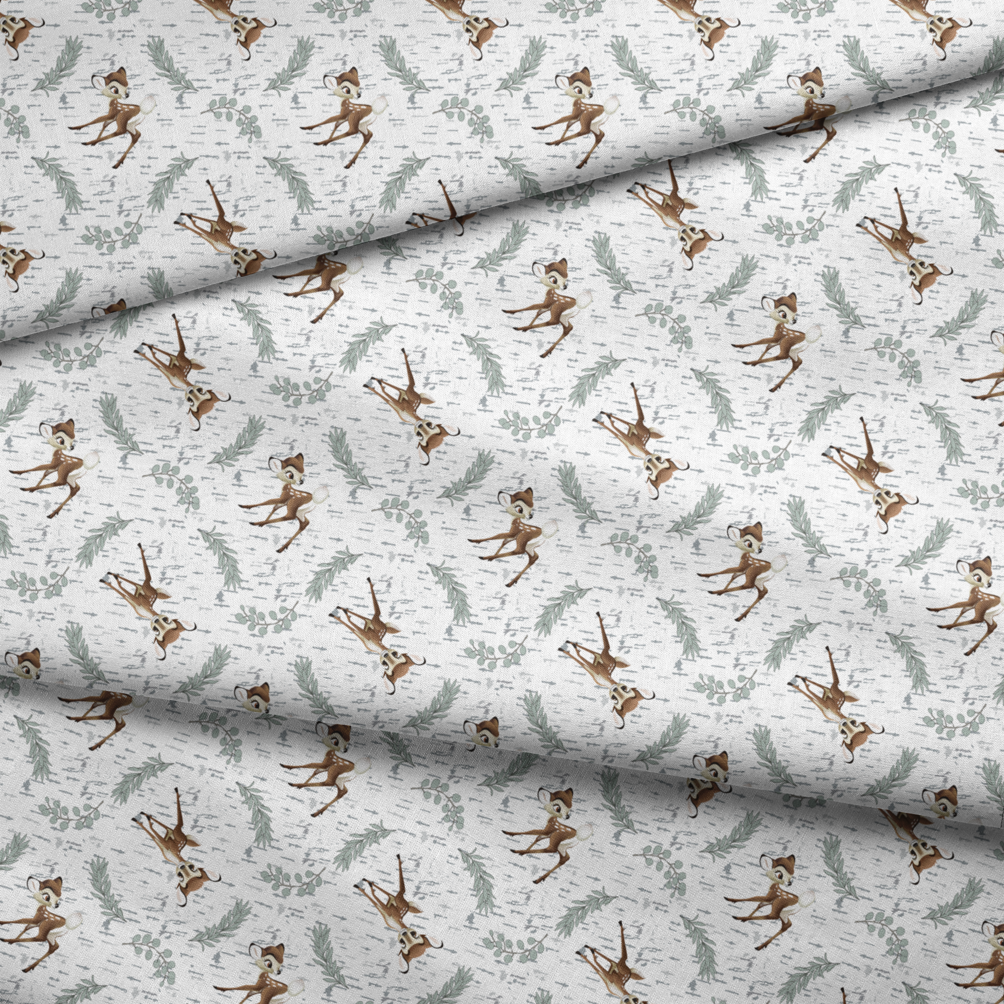Disney’s Bambi surrounded by sage green sprigs, leafy branches, and birch bark textures on a white background in a woodland-themed scattered repeat. fabric fold mockup