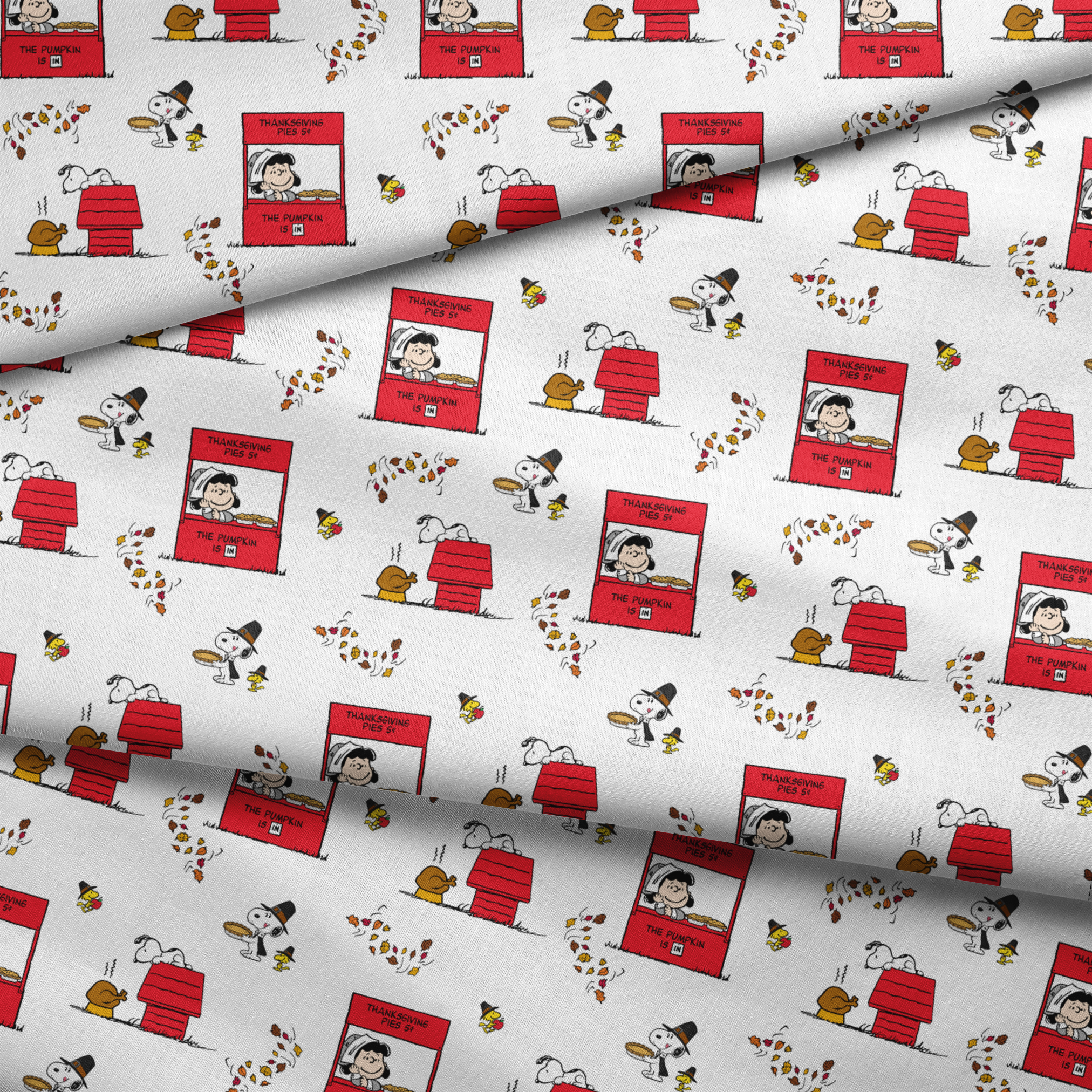 Peanuts Thanksgiving pattern with Snoopy, red booths, doghouses, and falling autumn leaves on white background fabric fold mockup