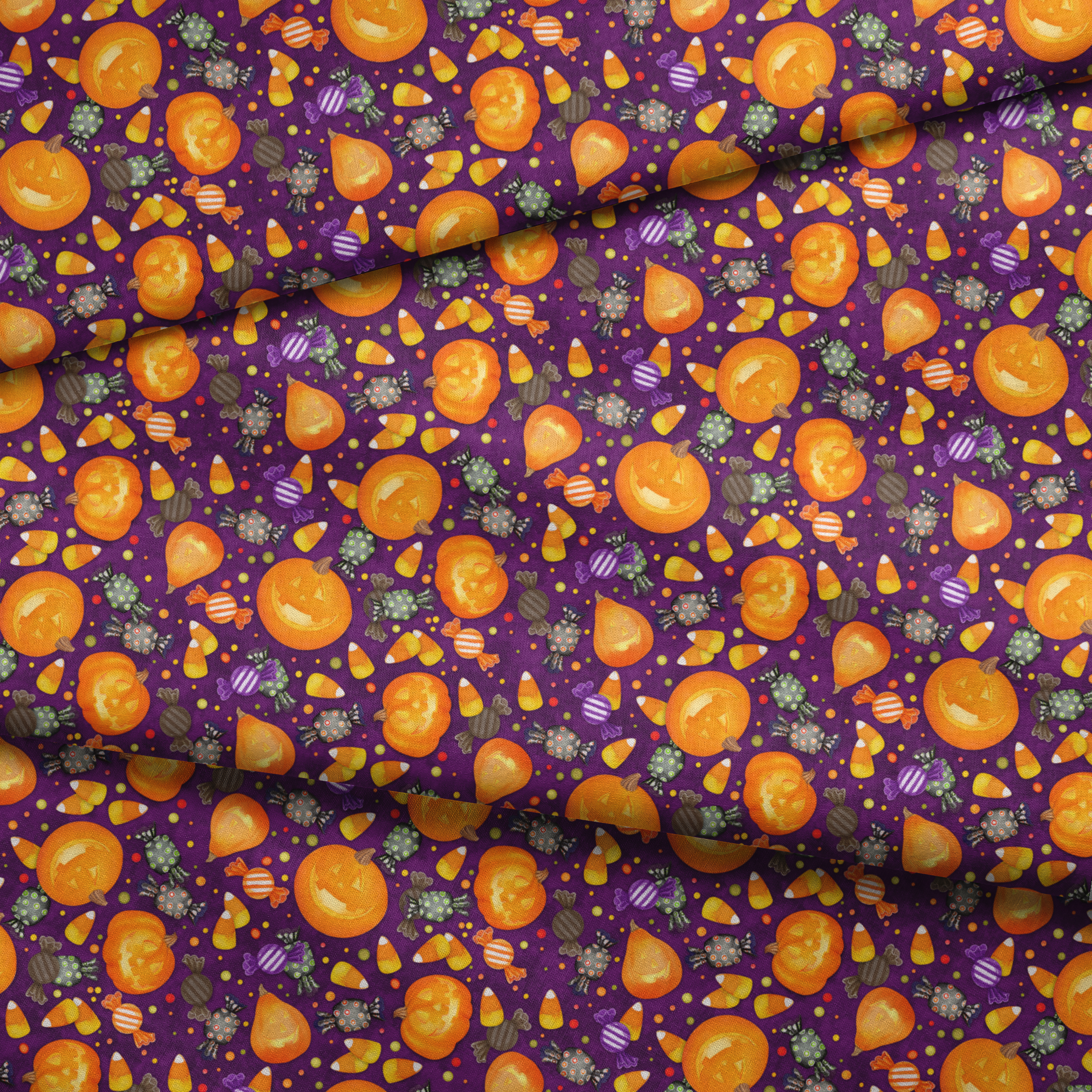 Playful Halloween fabric design by Nicole Tamarin featuring smiling jack-o’-lanterns, wrapped candies, and candy corn scattered across a purple background. fabric fold mockup