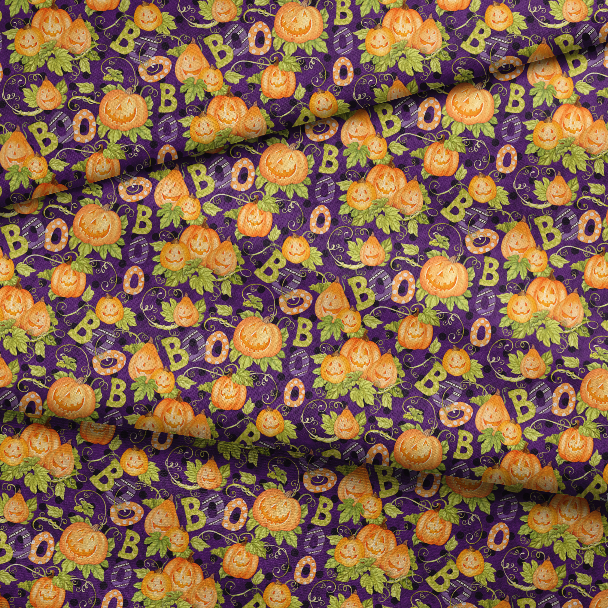 Halloween fabric by Nicole Tamarin with smiling jack-o’-lanterns, “BOO” text, vines, and leaves on a purple background. fabric fold mockup