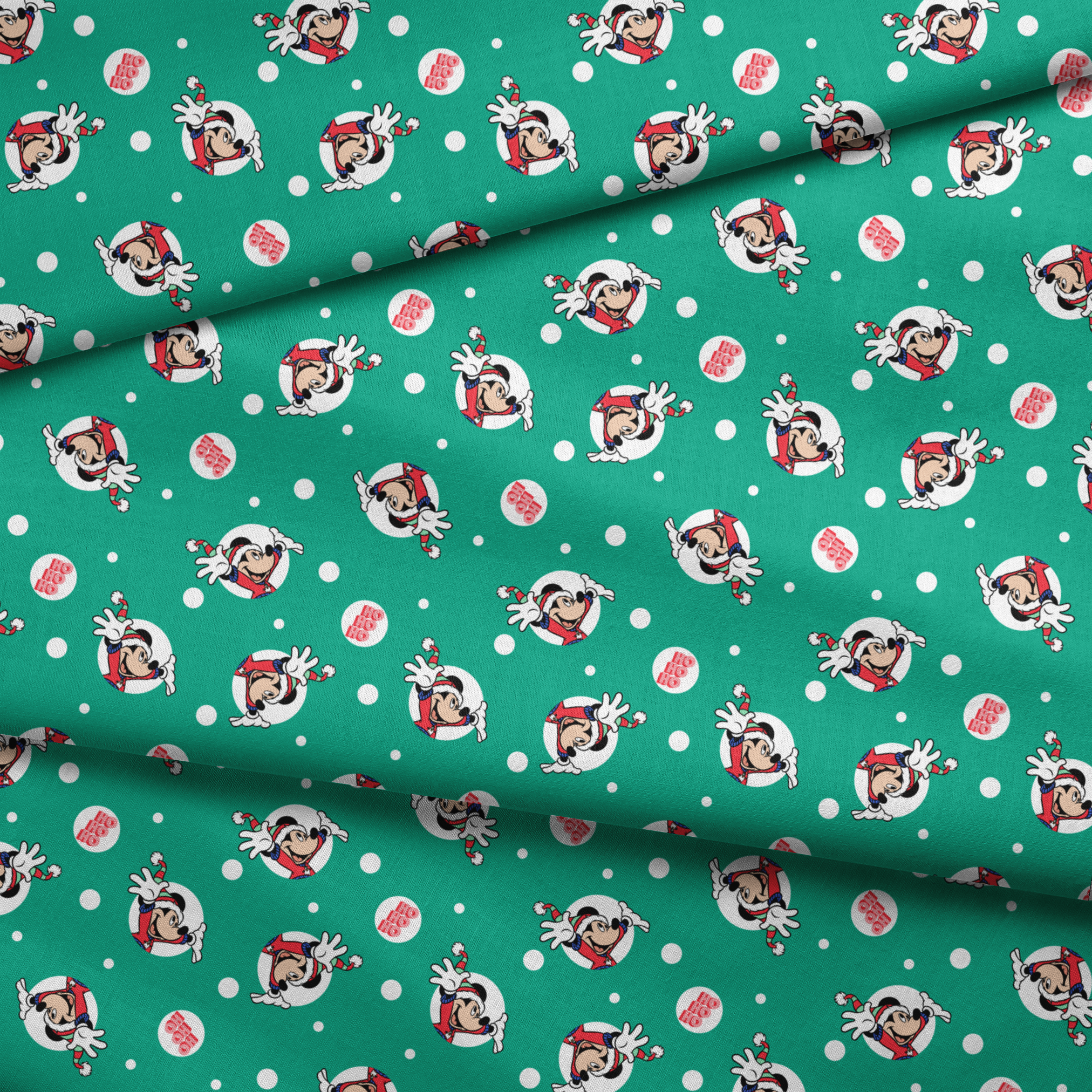 Mickey Mouse in Santa hats on green polka dot background with "Ho Ho Ho" text fabric fold mockup