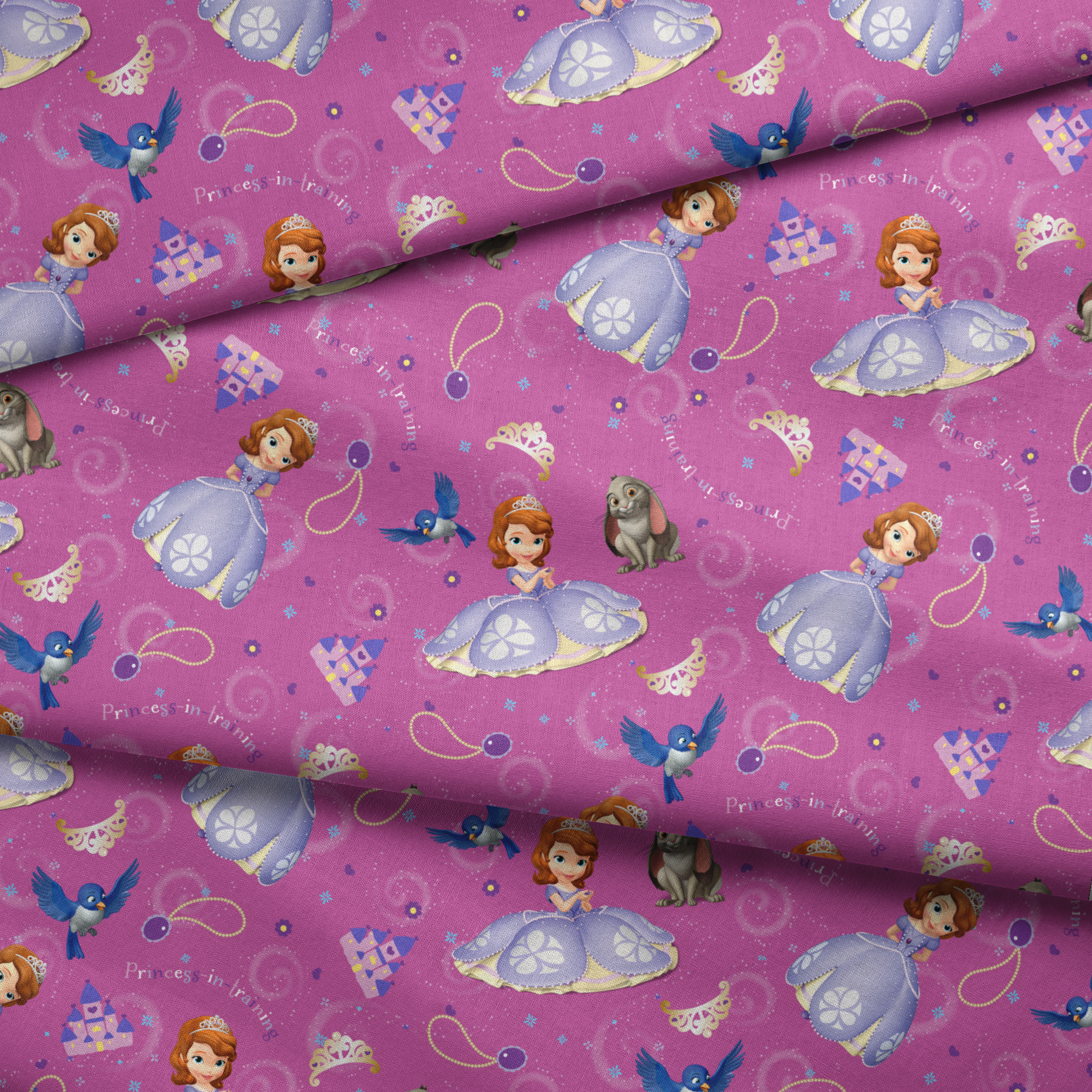 Princess Sofia pattern with purple background, crowns, castles, rabbits, and blue birds scattered among swirling designs fabric fold mockup