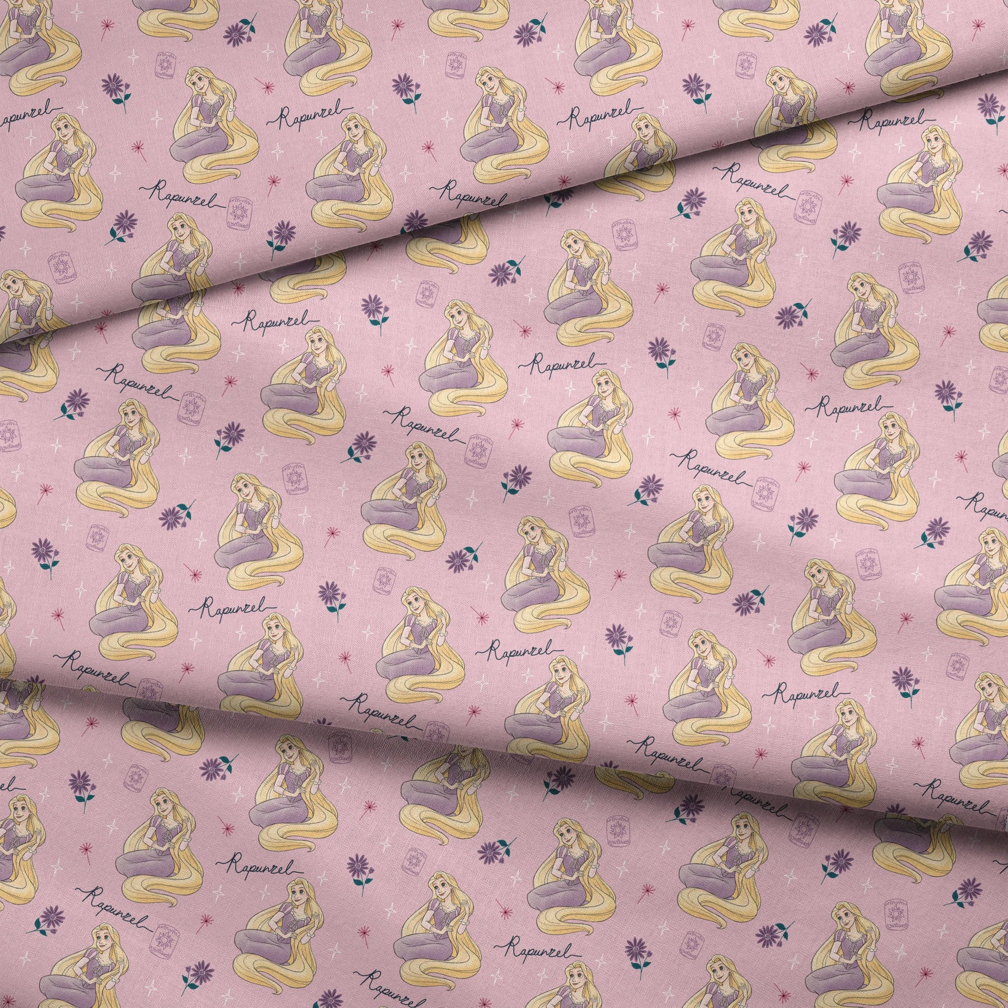 Repeating pattern of blonde character in purple dress with long flowing hair, flowers, and "Rapunzel" text on pink background fabric fold mockup