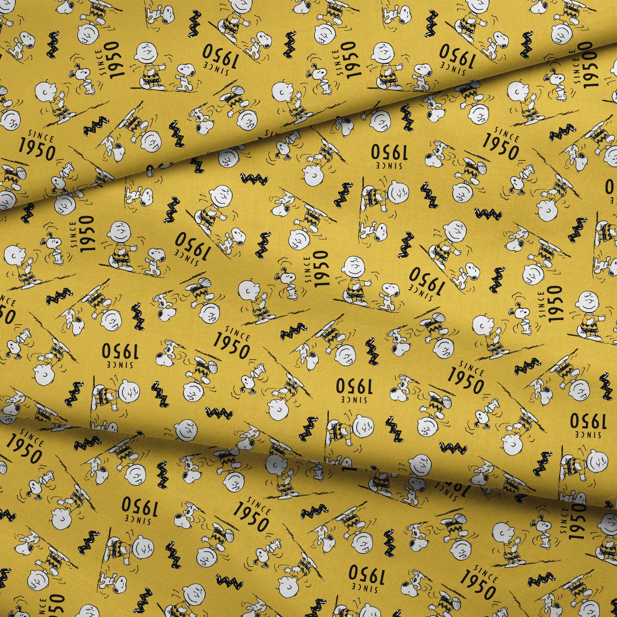 Peanuts cartoon pattern on yellow background with Snoopy and Charlie Brown, "Since 1950" text fabric fold mockup