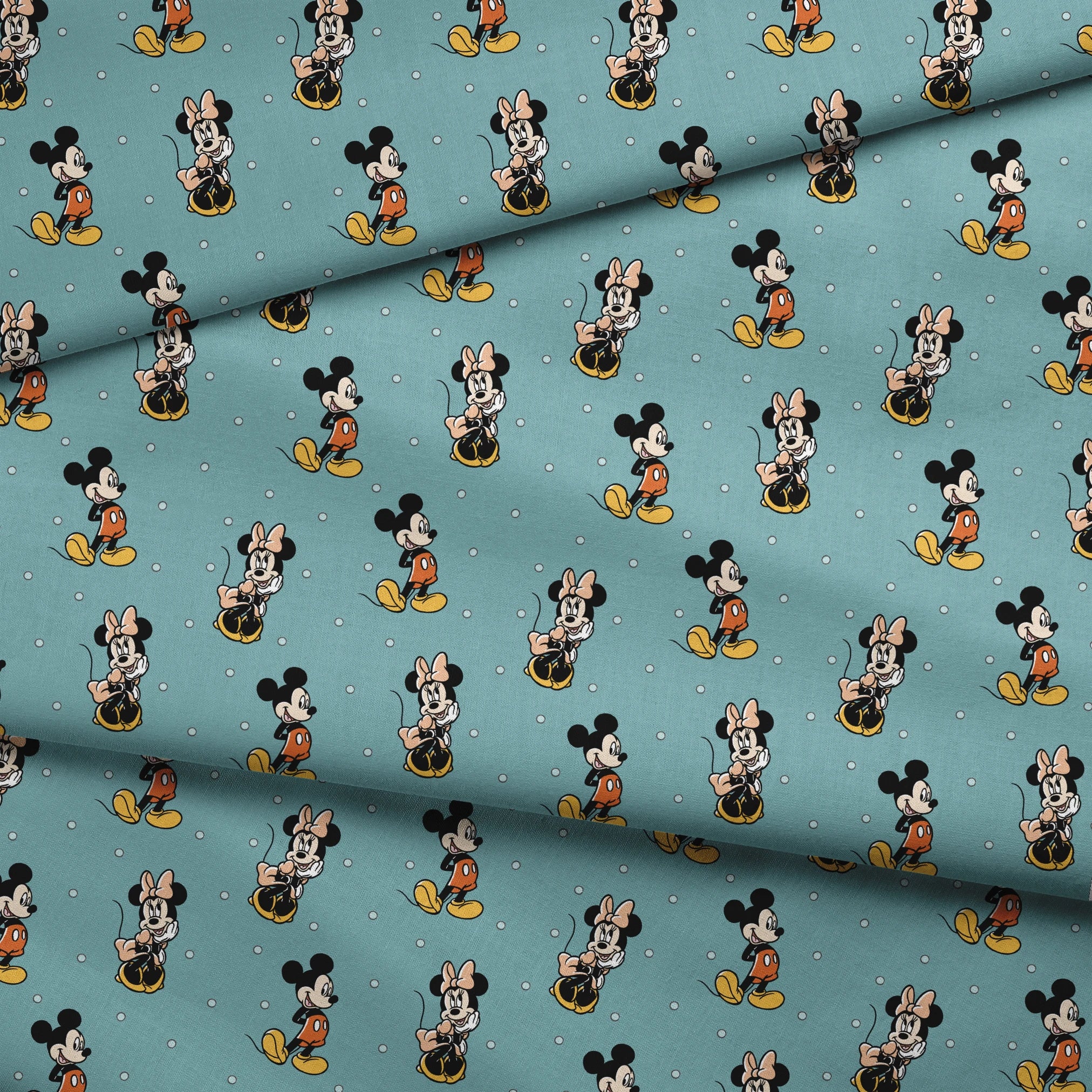 Cartoon pattern of Mickey and Minnie Mouse characters on light blue background with white dots fabric fold mockup