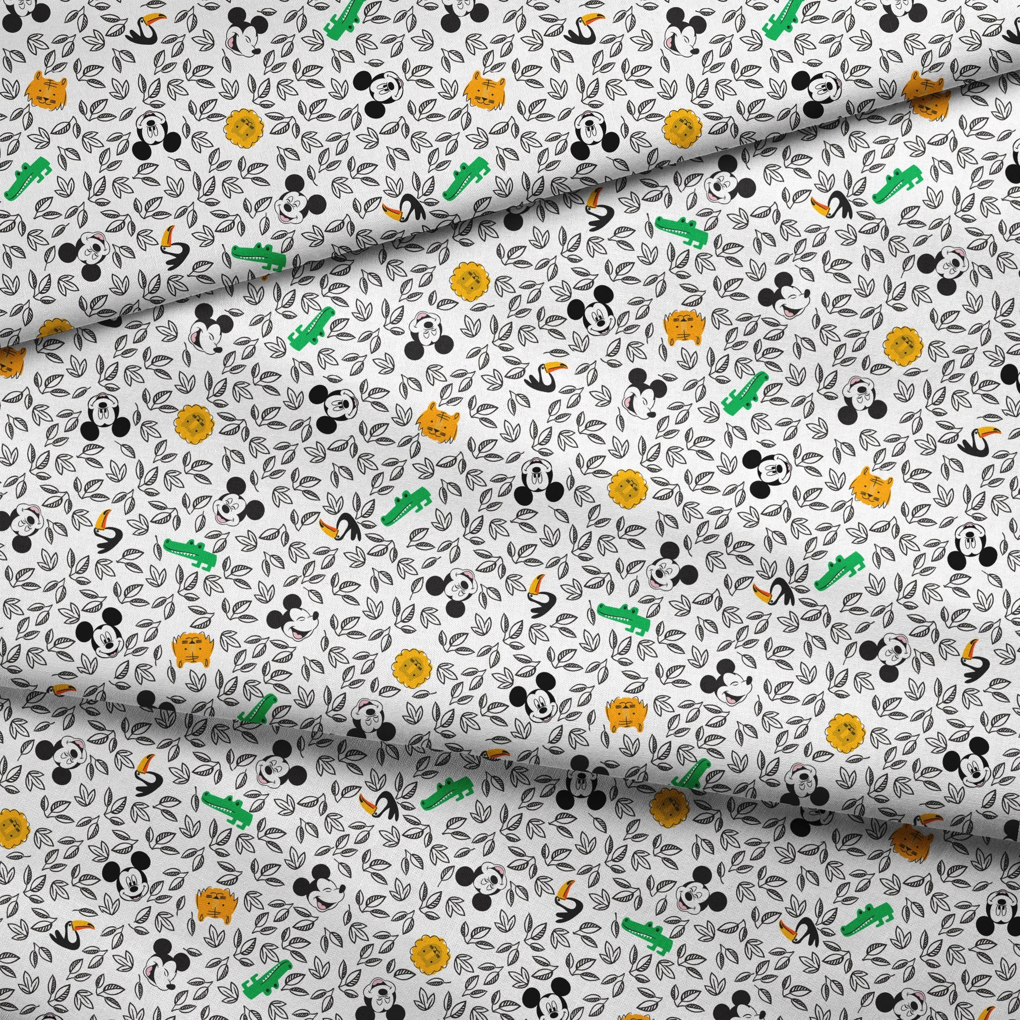 Pattern of cartoon Mickey Mouse silhouettes with yellow honeycomb, green bamboo, and black and white leaves fabric fold mockup
