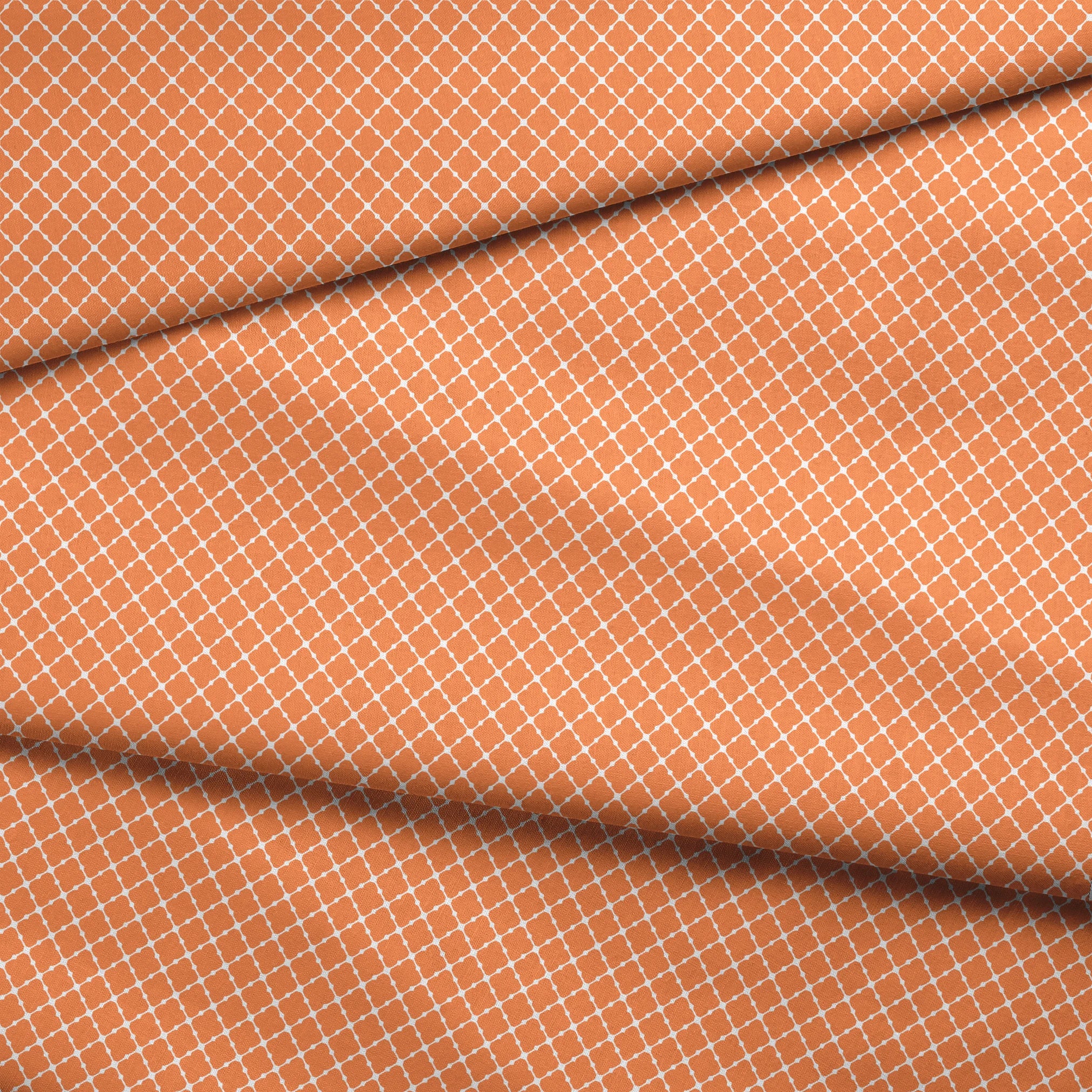 Geometric orange and white pattern with quatrefoil shapes forming a lattice design fabric fold mockup
