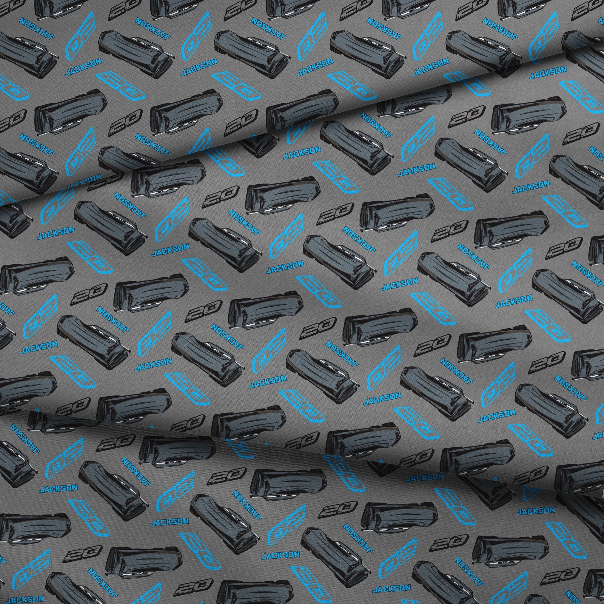 Dark gray background with scattered black car parts and blue "JACKSON" text and stylized logos in a repeating pattern fabric fold mockup