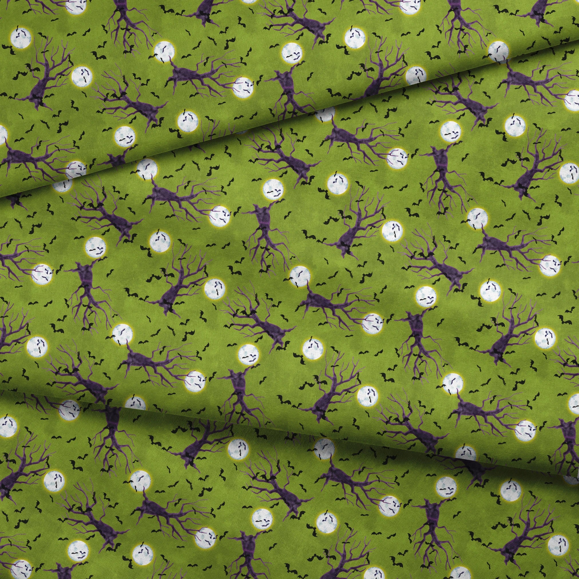 Halloween fabric design with purple haunted trees, bats, and glowing moons on a green background, illustrated by Nicole Tamarin. fabric fold mockup