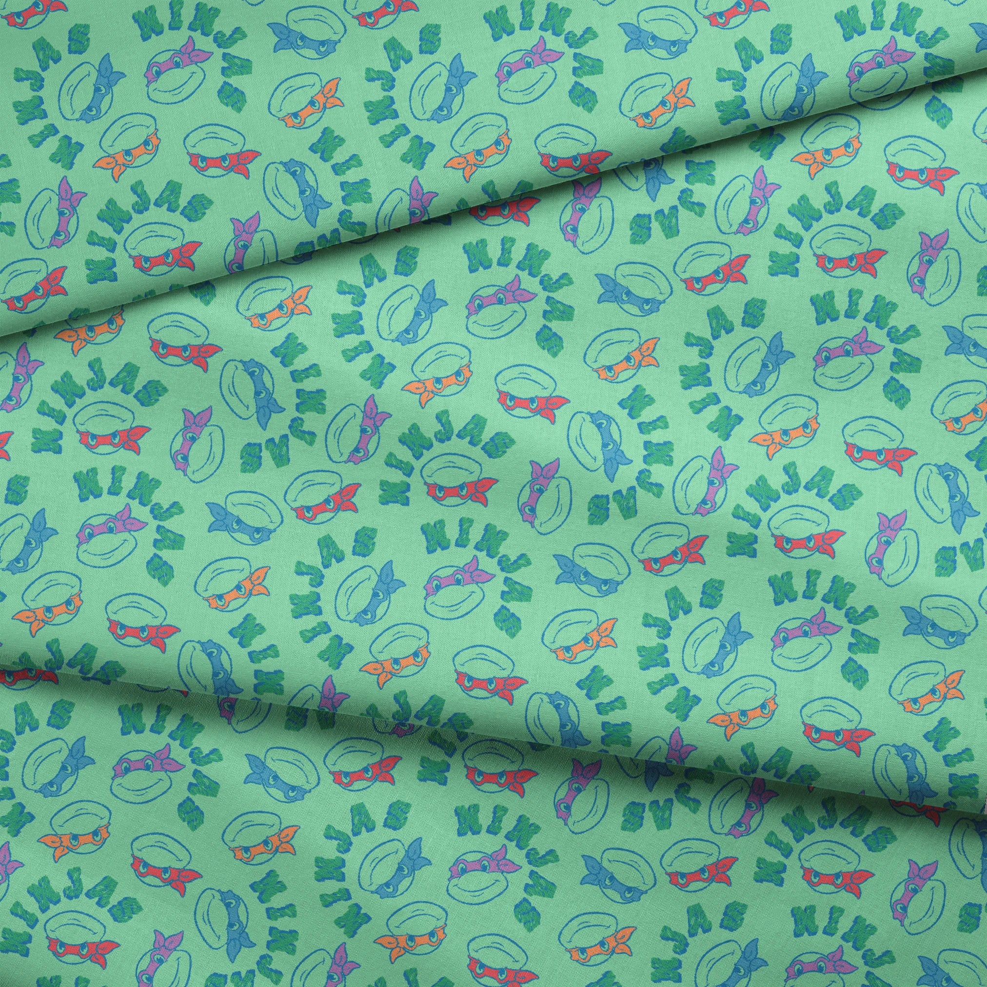 Pattern of Teenage Mutant Ninja Turtles with colored masks in blue, red, and purple on mint green background fabric fold mockup