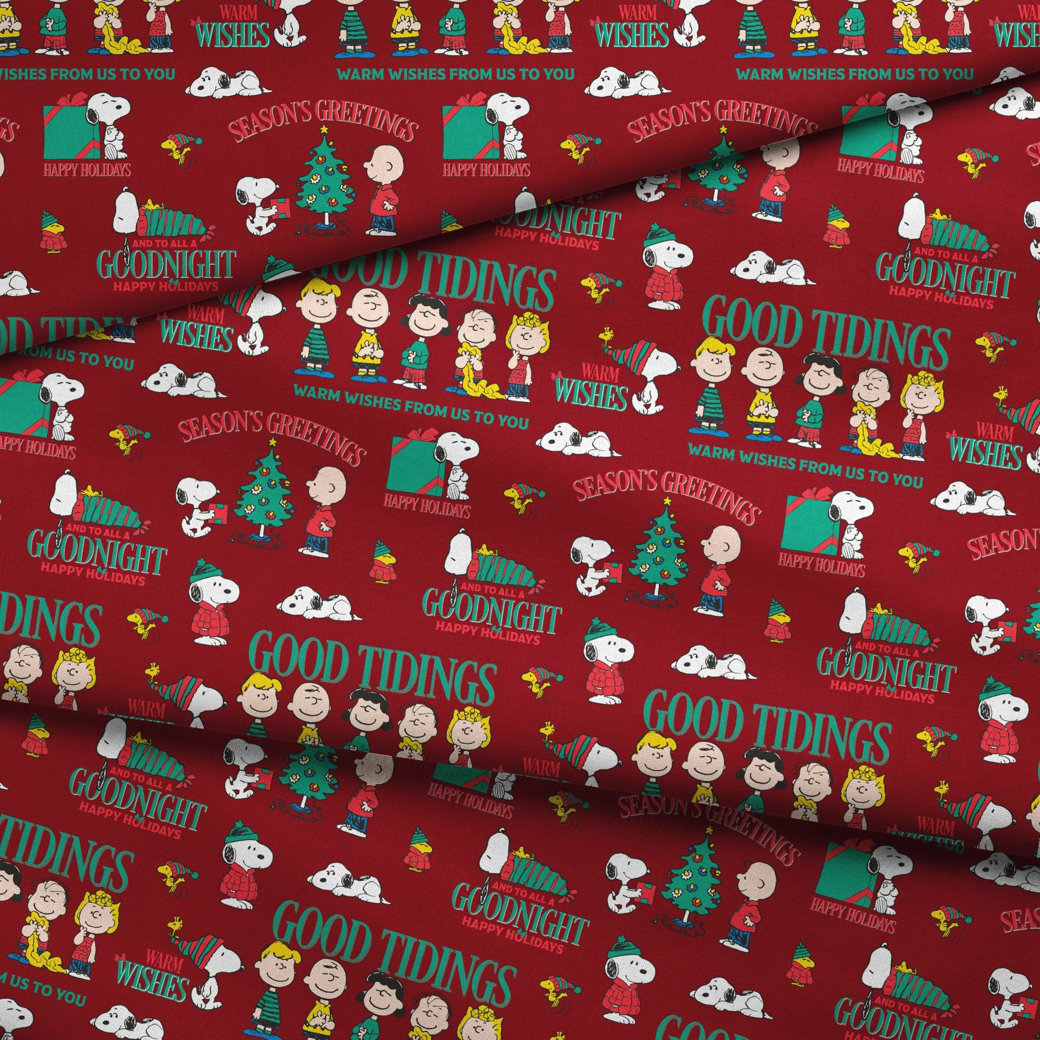 Colorful Peanuts Christmas pattern with Snoopy, Woodstock, and friends with holiday phrases on red background fabric fold mockup
