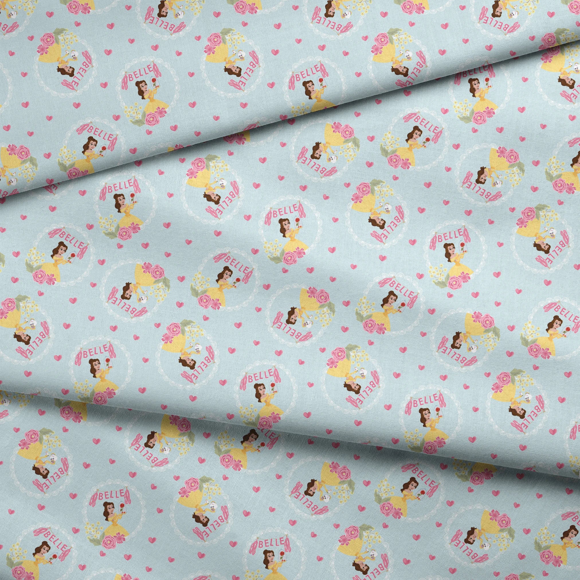 Princess Belle pattern with yellow dress, "Belle" text, hearts, and flowers on light blue background fabric fold mockup