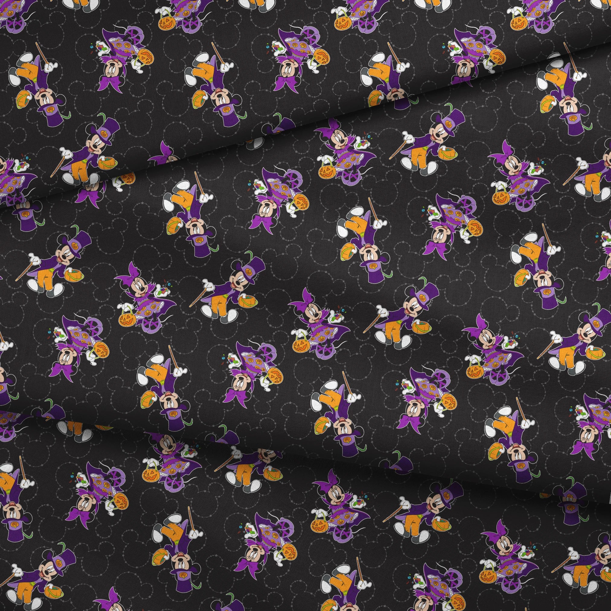 Mickey and Minnie in Halloween costumes on black background with purple, orange, and white details in a scattered pattern fabric fold mockup
