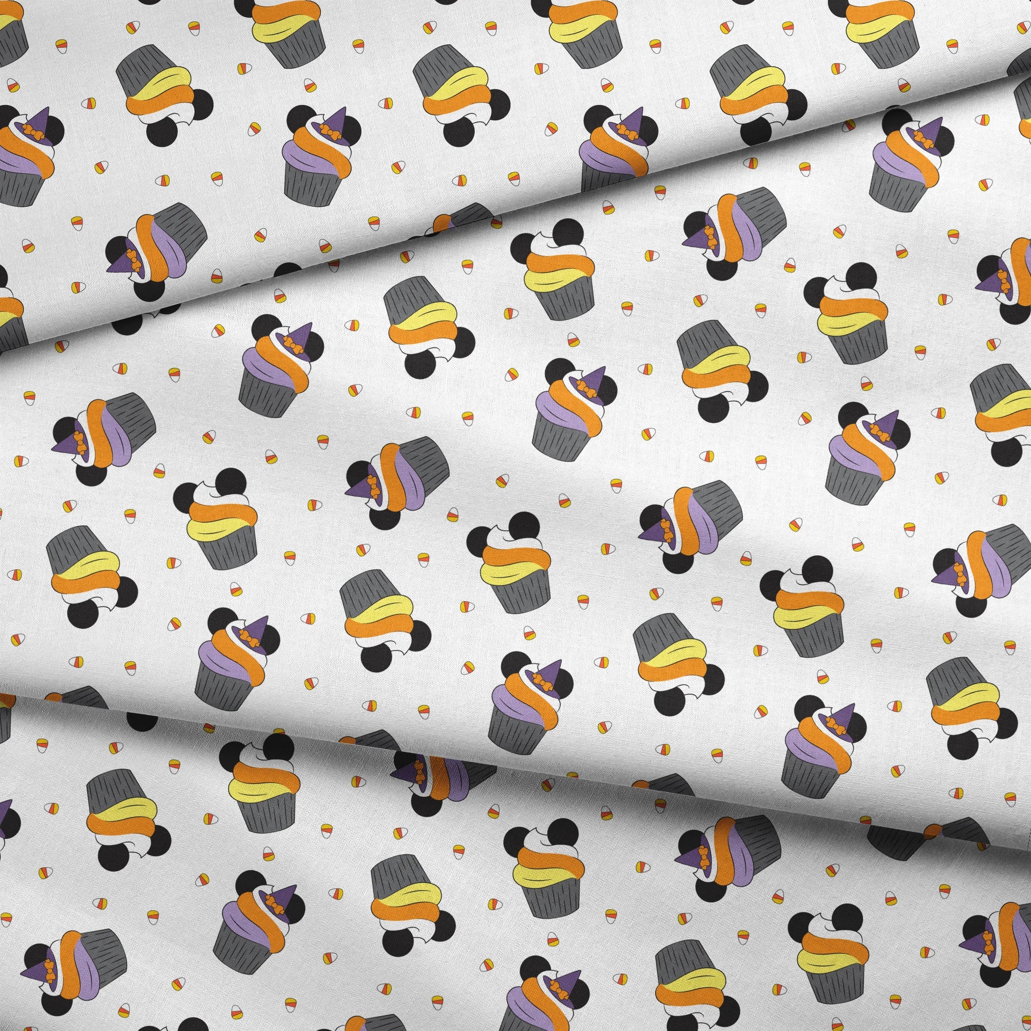 Disney cupcakes with black circular elements and colorful frosting in orange, yellow, and purple on a white background. fabric fold mockup