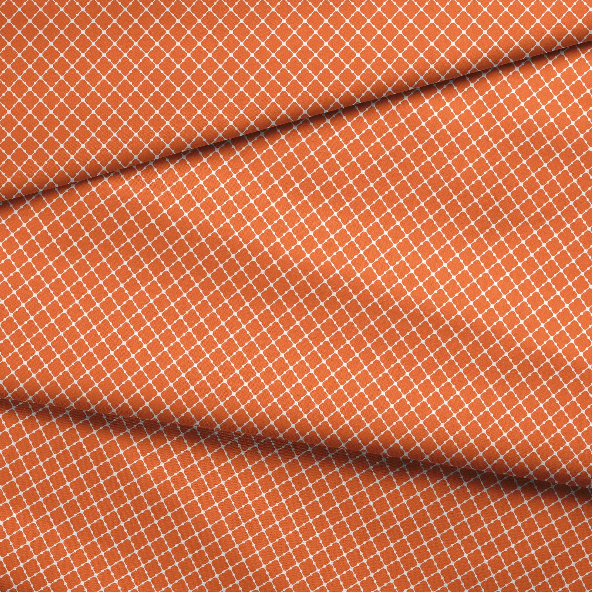 Burnt Orange and white quatrefoil pattern with smooth lattice design on orange background fabric fold mockup