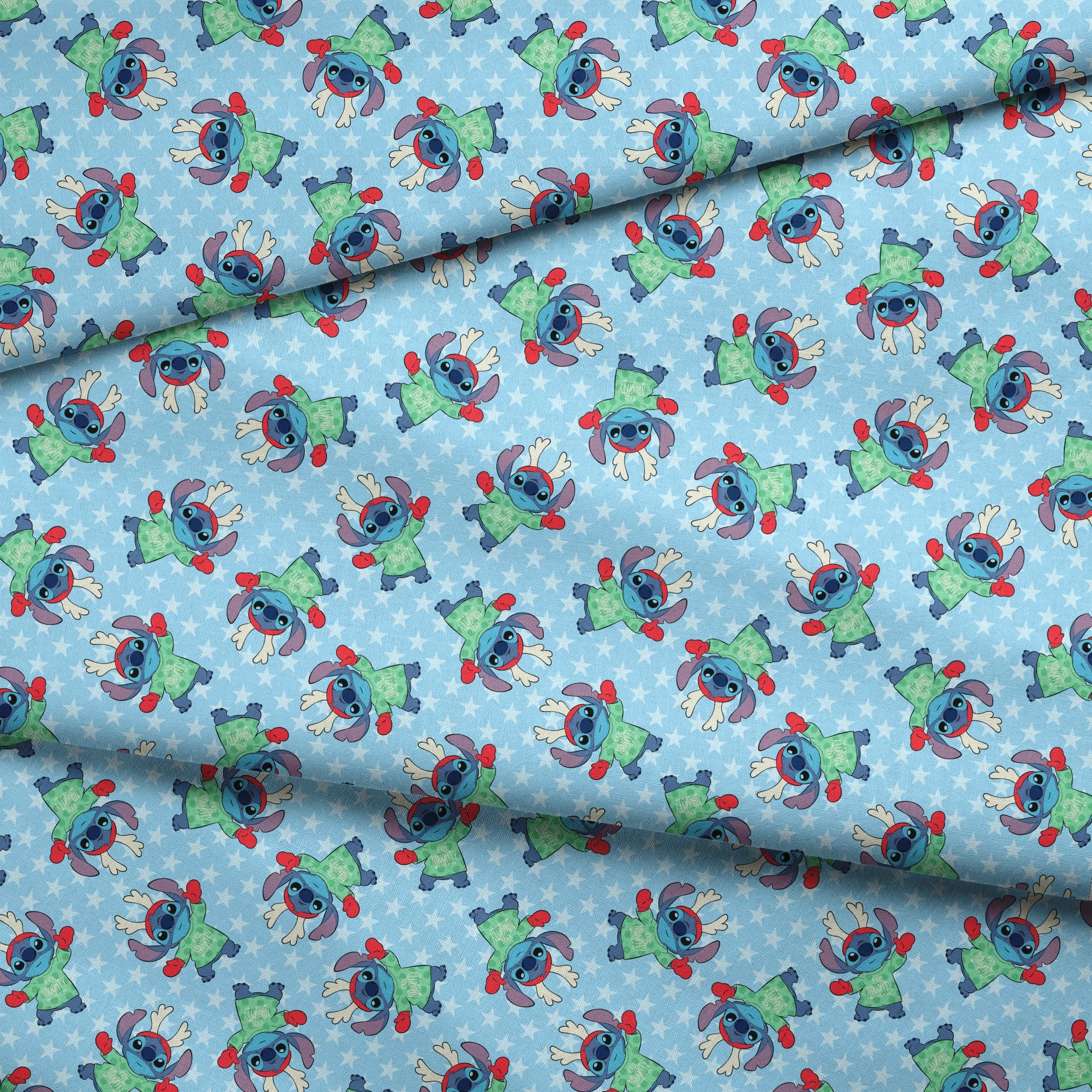 A repeating pattern of Disney's Stitch in holiday outfits with Christmas trees on light blue snowflake background. fabric fold mockup