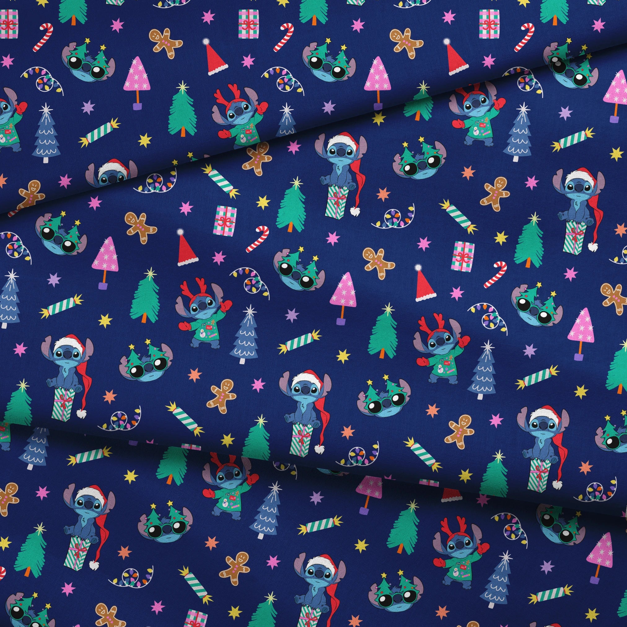 Festive Christmas pattern with Stitch, trees, candy canes, presents, and gingerbread men on navy background fabric fold mockup
