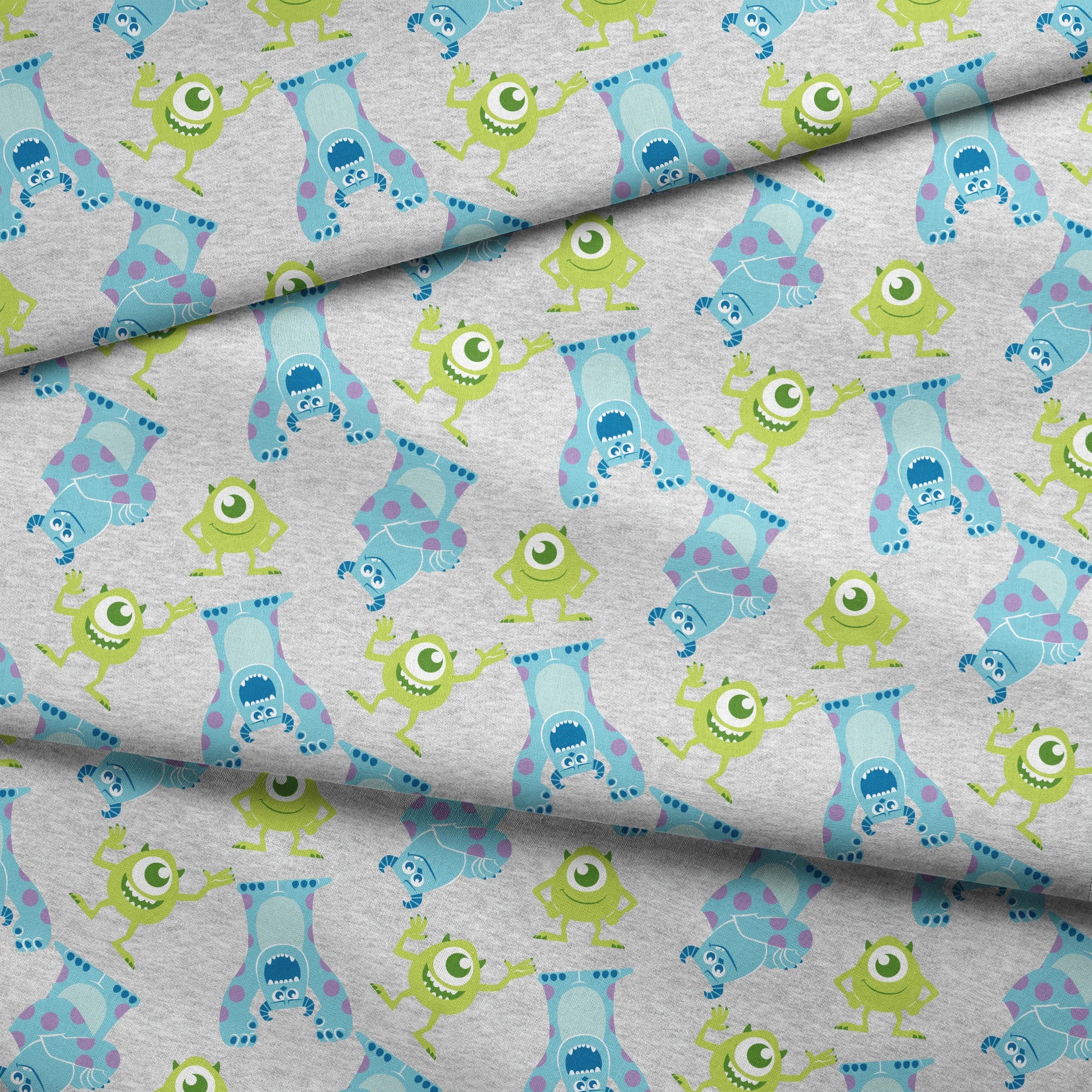 Cartoon pattern of Monsters Inc characters on light gray background fabric fold mockup