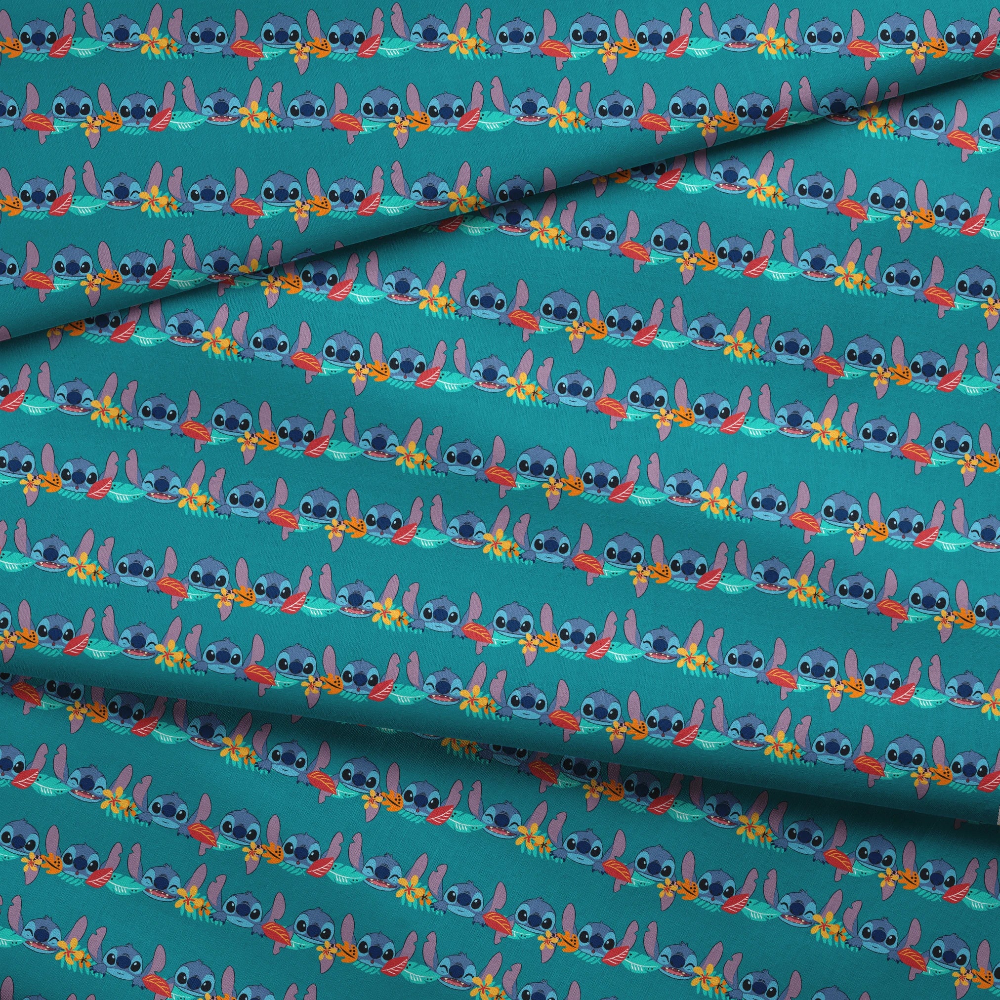 Repeating stripe design with Disney’s Stitch peeking between rows of tropical hibiscus flowers and colorful leaves on a teal background. fabric fold mockup