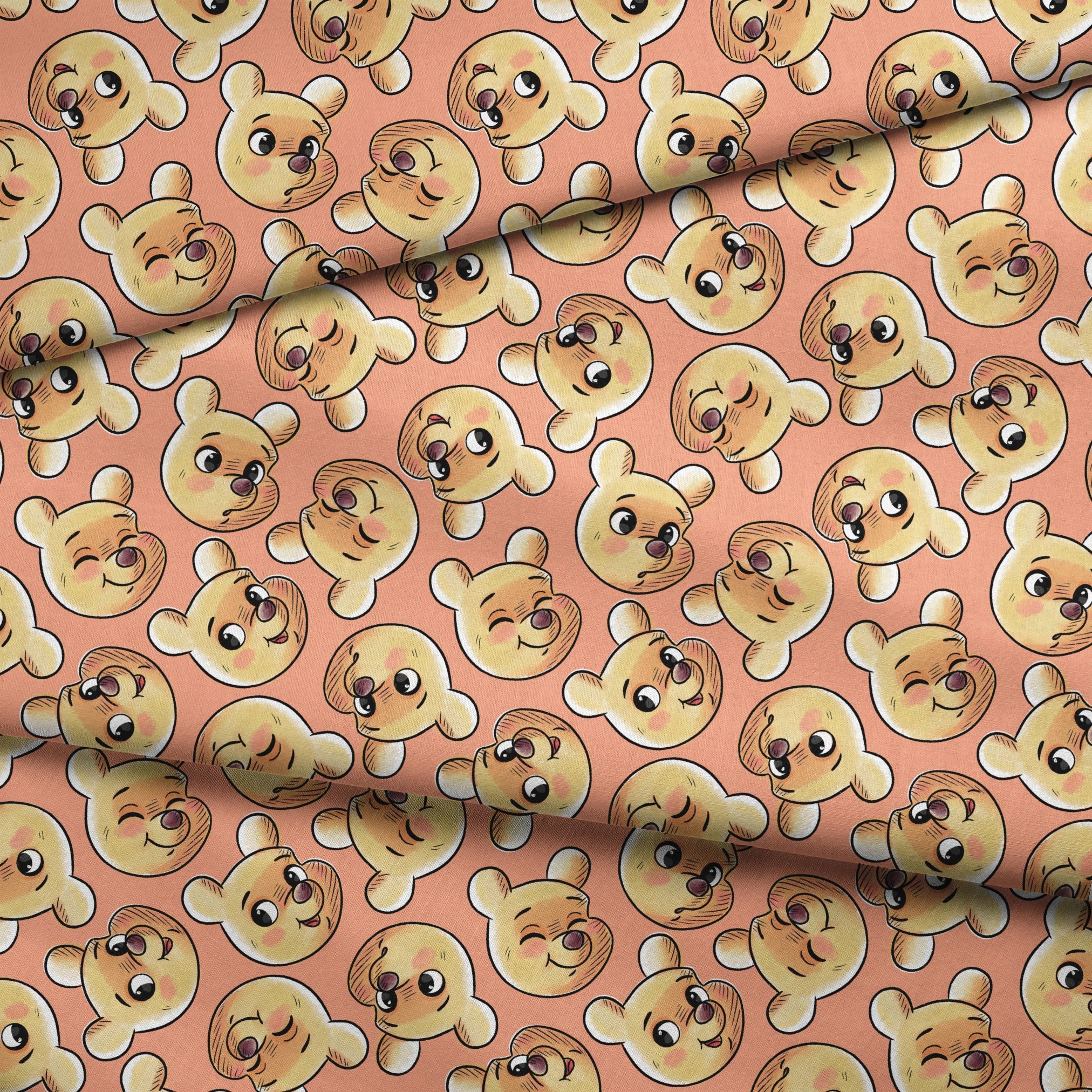 Cartoon teddy bear faces with cute expressions on peach background in repeating pattern fabric fold mockup