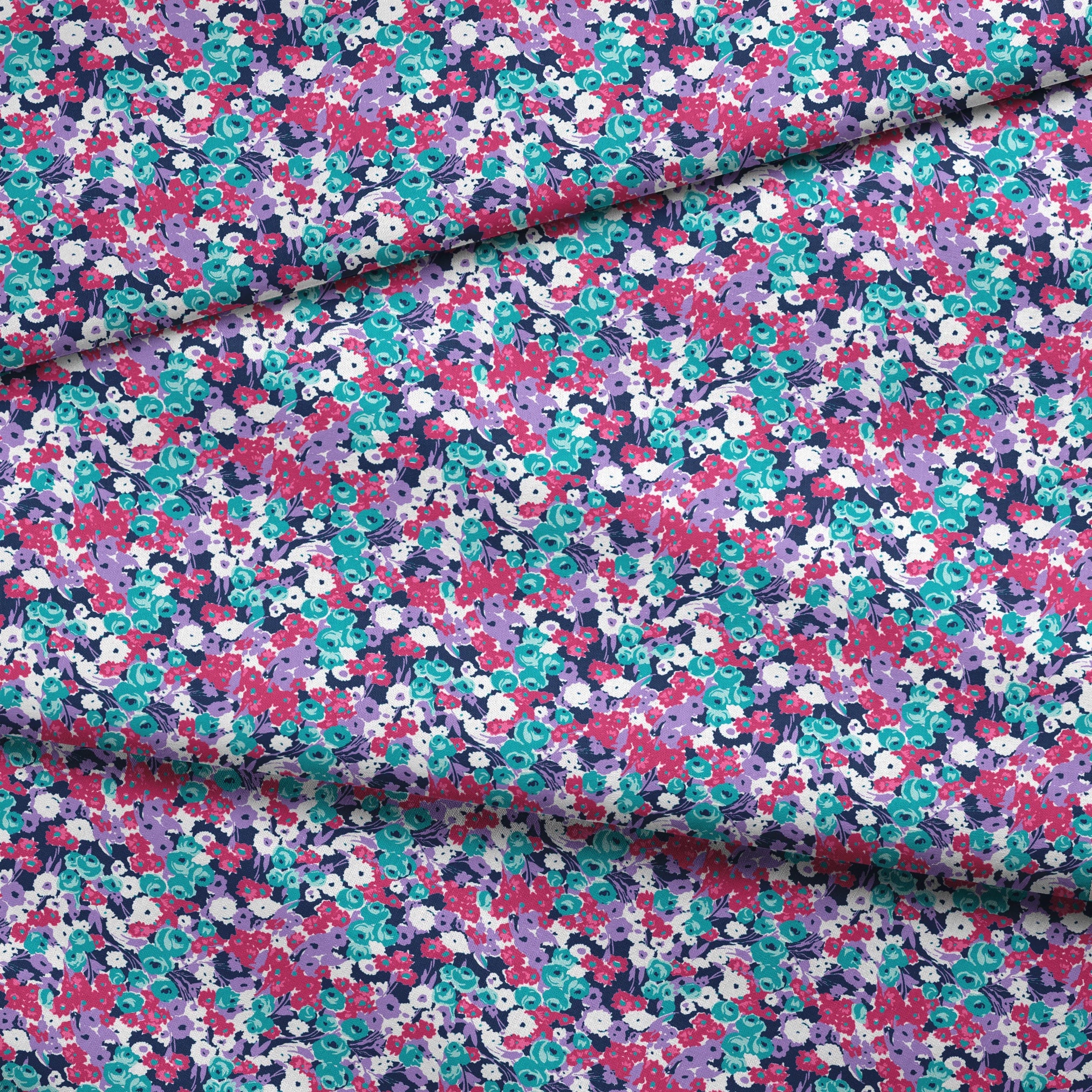 Vibrant floral pattern with pink, white, purple, and turquoise flowers on dark indigo background fabric fold mockup