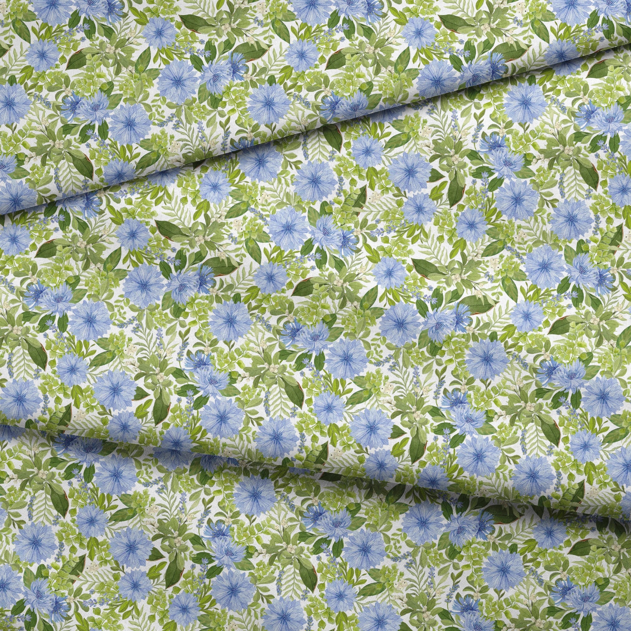 Watercolor-style botanical fabric pattern featuring blue wildflowers and soft green foliage on a white background. Designed by Nicole Tamarin. fabric fold mockup