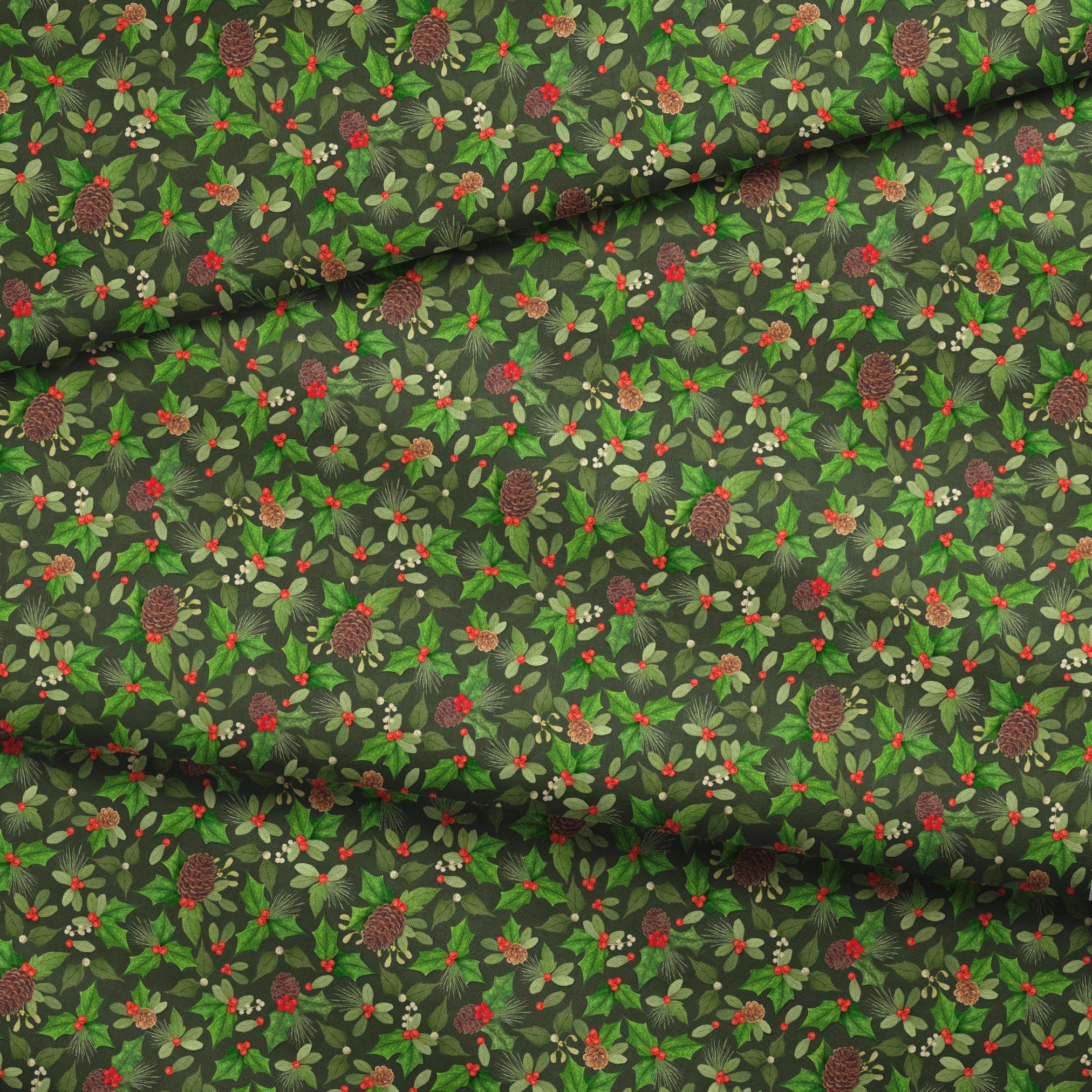 Seamless holiday pattern by Nicole Tamarin featuring pinecones, holly, red berries, and green foliage on a dark green background. fabric fold mockup