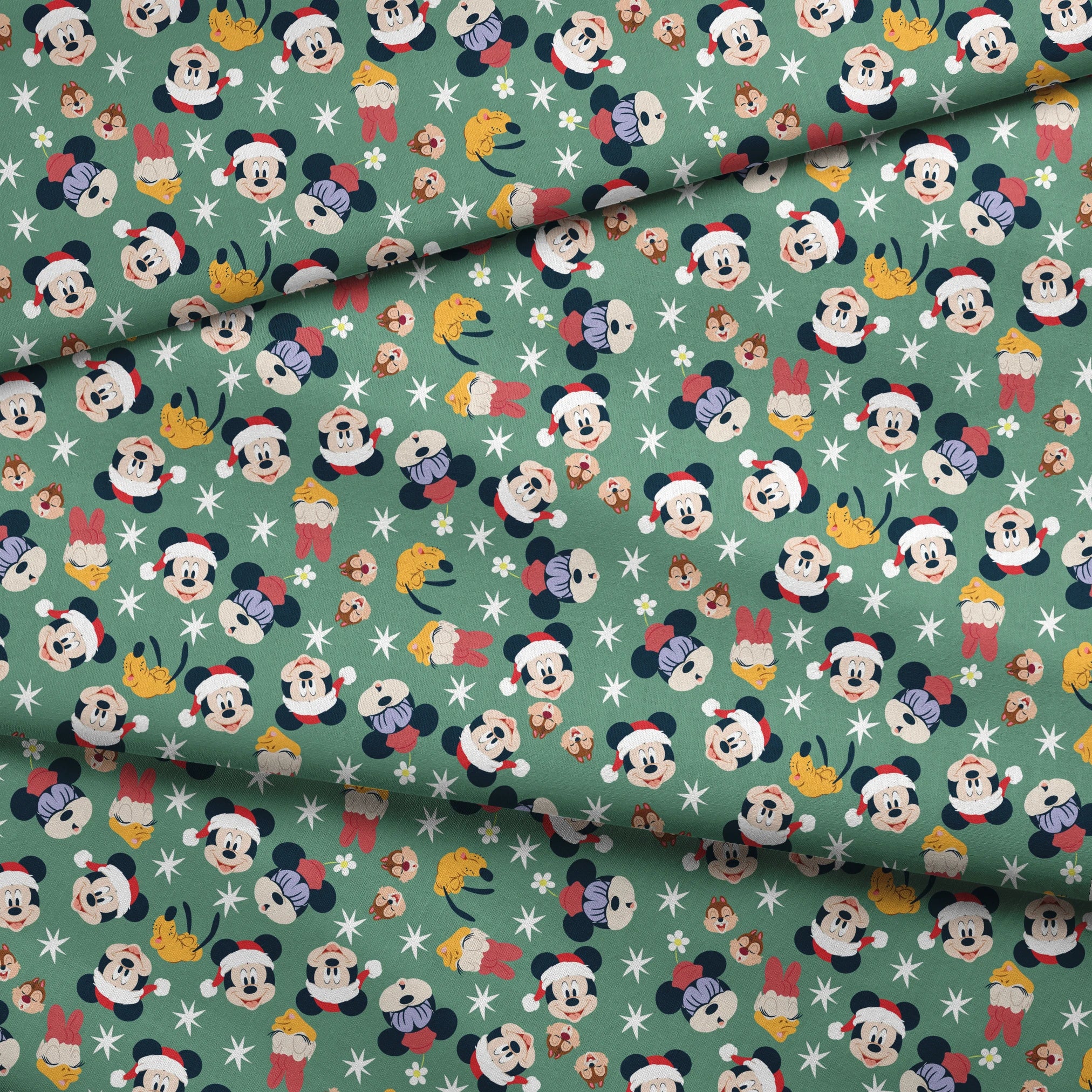 Mickey Mouse holiday pattern with characters wearing Santa hats on green background with stars and ornaments fabric fold mockup