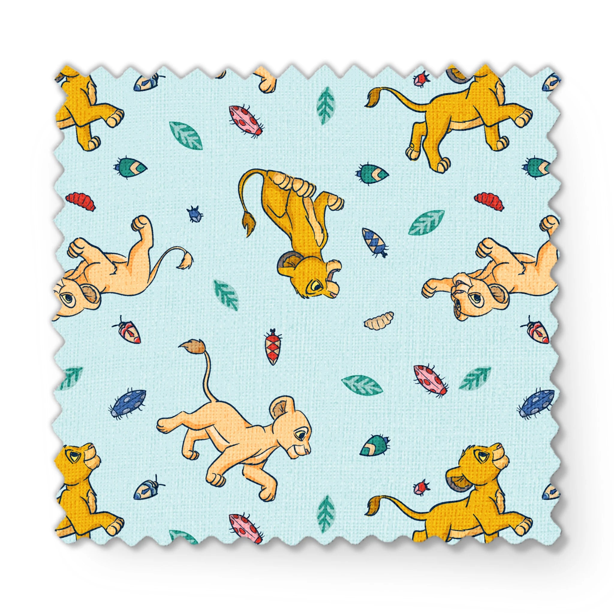 Lion cubs playing on light blue background with colorful leaves and plant elements scattered throughout fabric swatch mockup