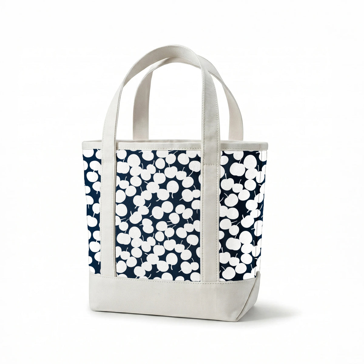 White cherry silhouettes scattered across a deep navy blue background in a playful pattern springs canvastote mockup