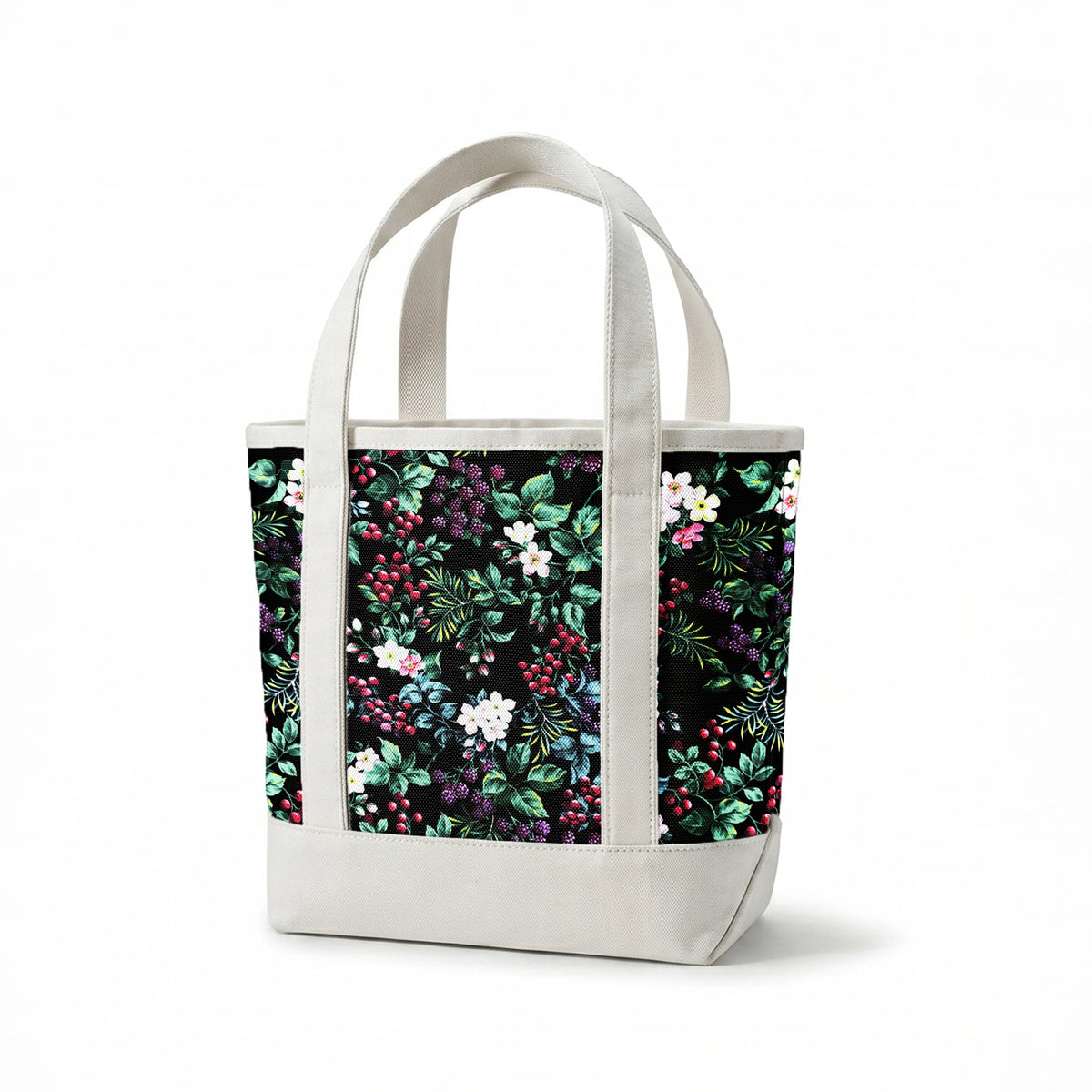 Colorful botanical pattern with white flowers, red cherries, purple blackberries, and green leaves on black background springs canvastote mockup