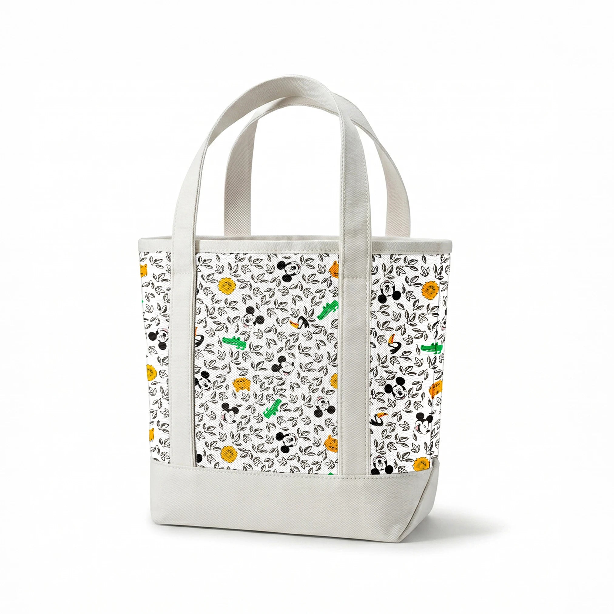 Pattern of cartoon Mickey Mouse silhouettes with yellow honeycomb, green bamboo, and black and white leaves springs canvastote mockup