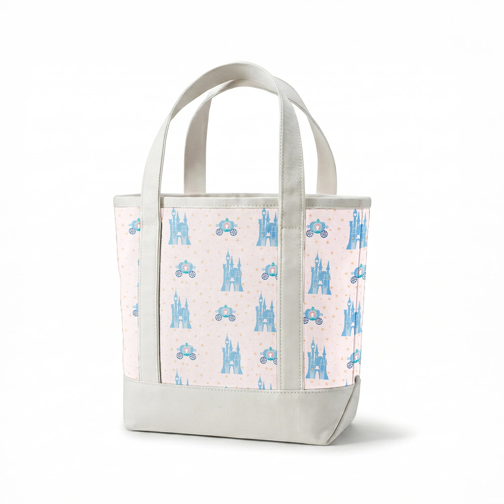 Cinderella pattern with blue castles, carriages, and gold stars on pale pink background springs canvastote mockup