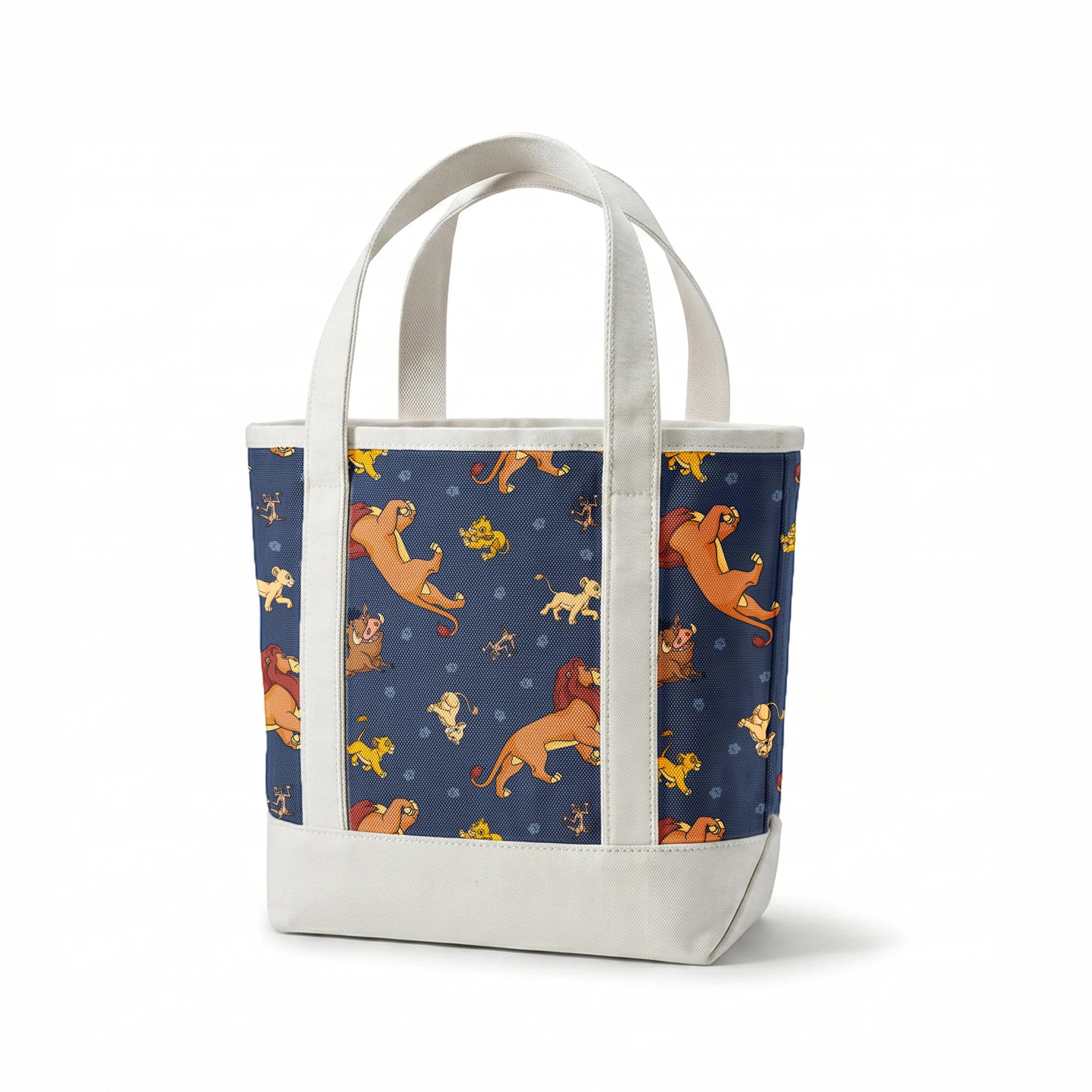 Colorful cartoon lions and characters from The Lion King scattered on dark blue background with paw prints springs canvastote mockup