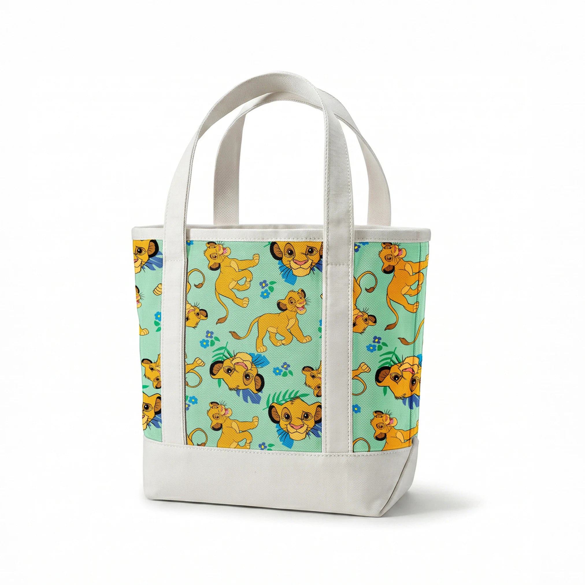 Cartoon lion cubs playing on mint green background with blue flowers and green leaves pattern springs canvastote mockup