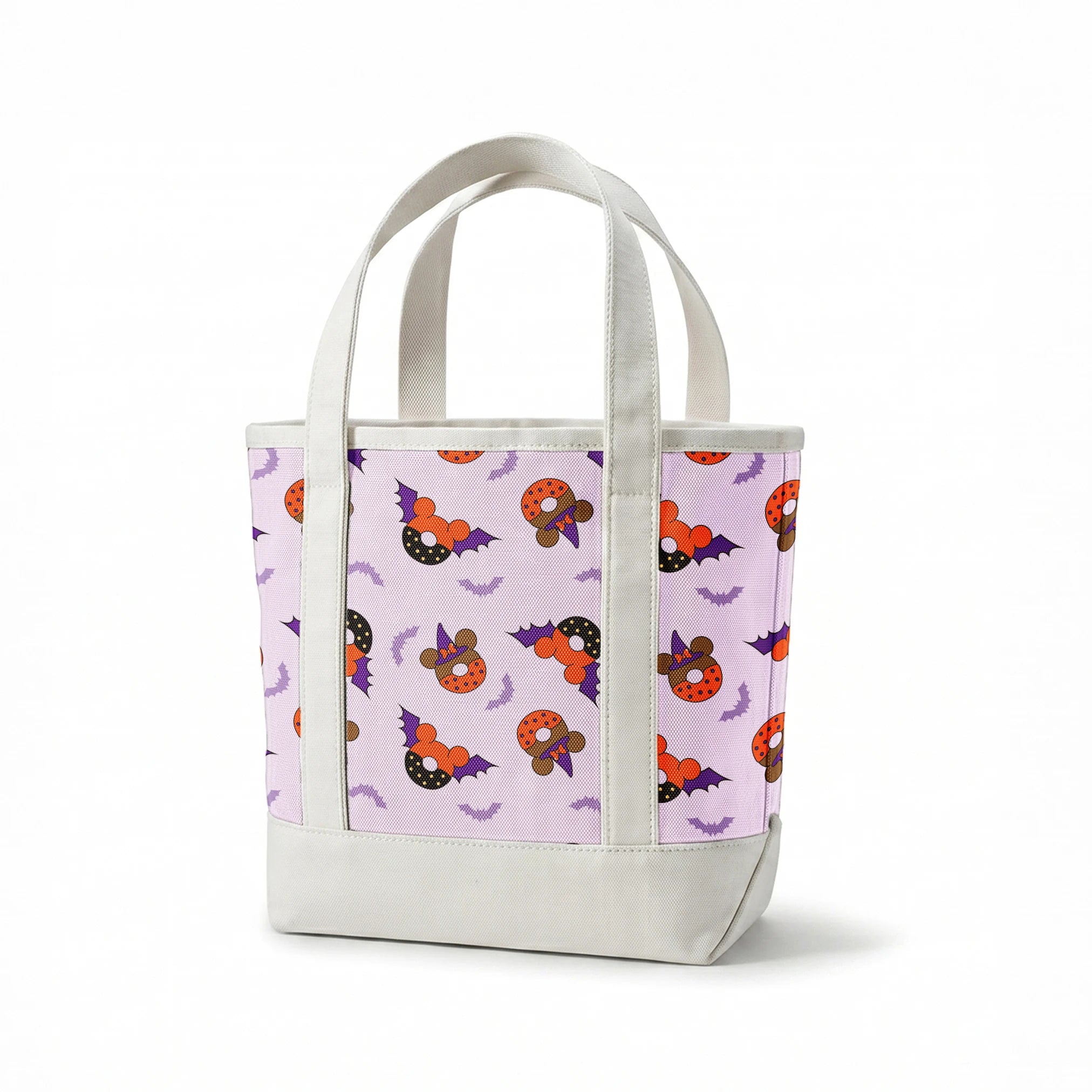 Disney Halloween-themed pattern with orange and black donuts, purple bat wings, and light purple bats on lavender background springs canvastote mockup