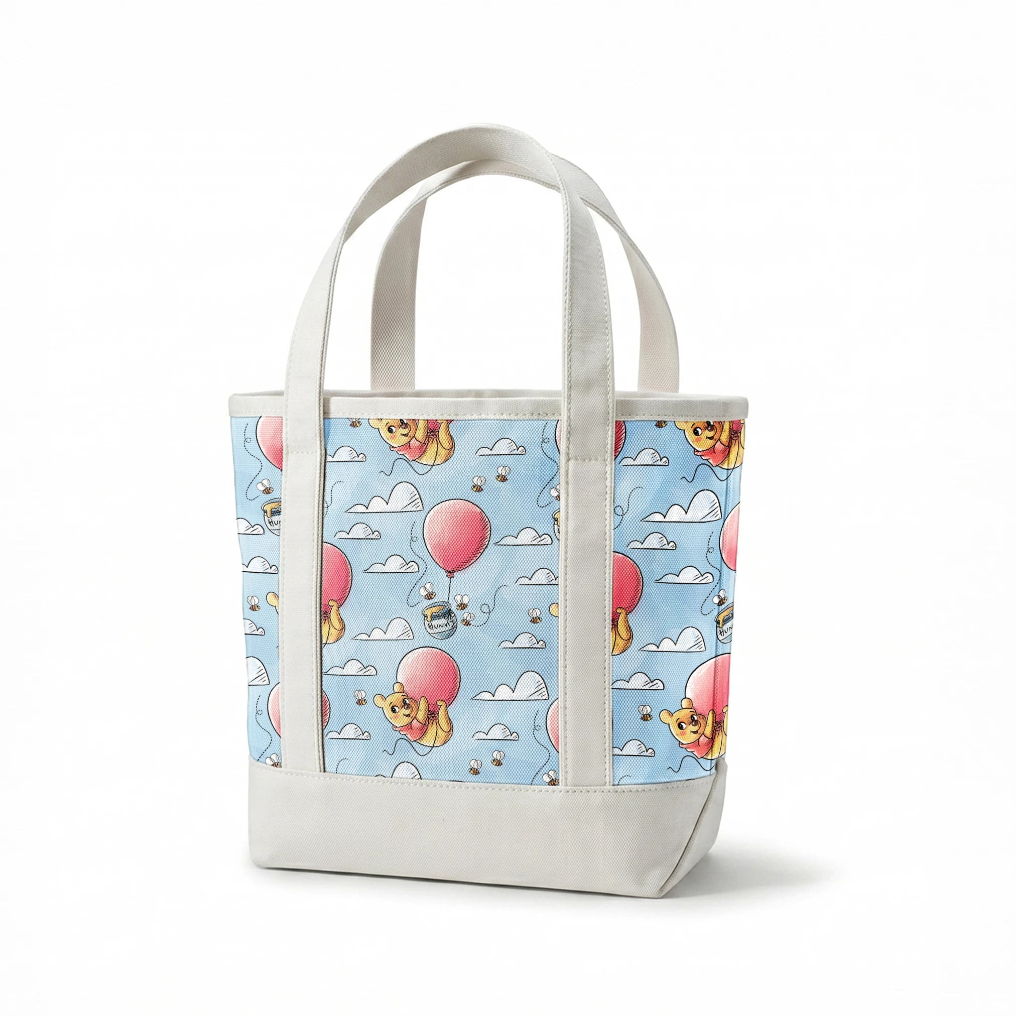 Cute yellow bear characters floating with pink balloons and honey pots against a blue sky with cl... springs canvastote mockup