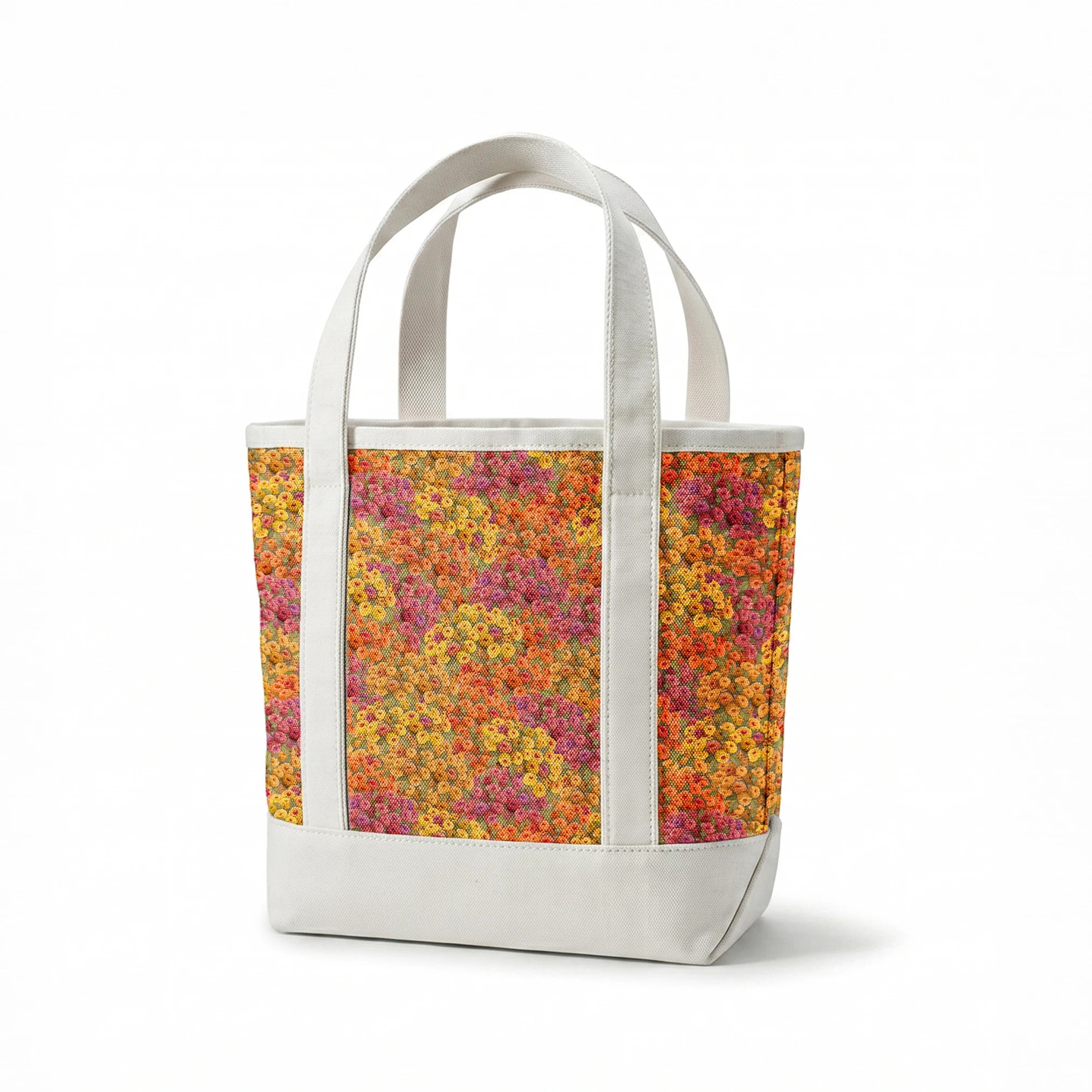 Dense floral fabric featuring orange, gold, pink, and plum zinnias in a packed all-over pattern by Nicole Tamarin. springs canvastote mockup