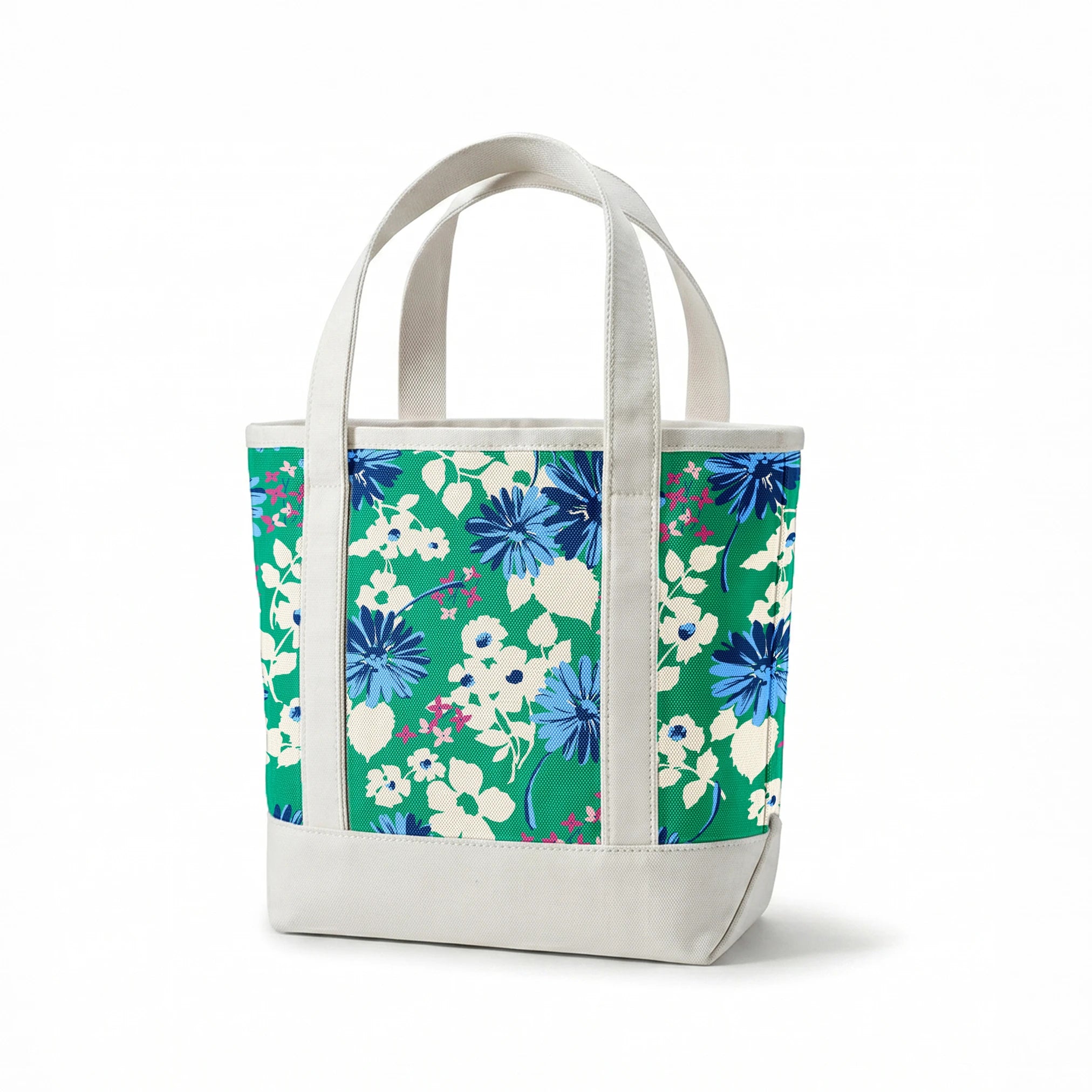 Vibrant floral pattern with blue spiky flowers and white blooms on a green background springs canvastote mockup