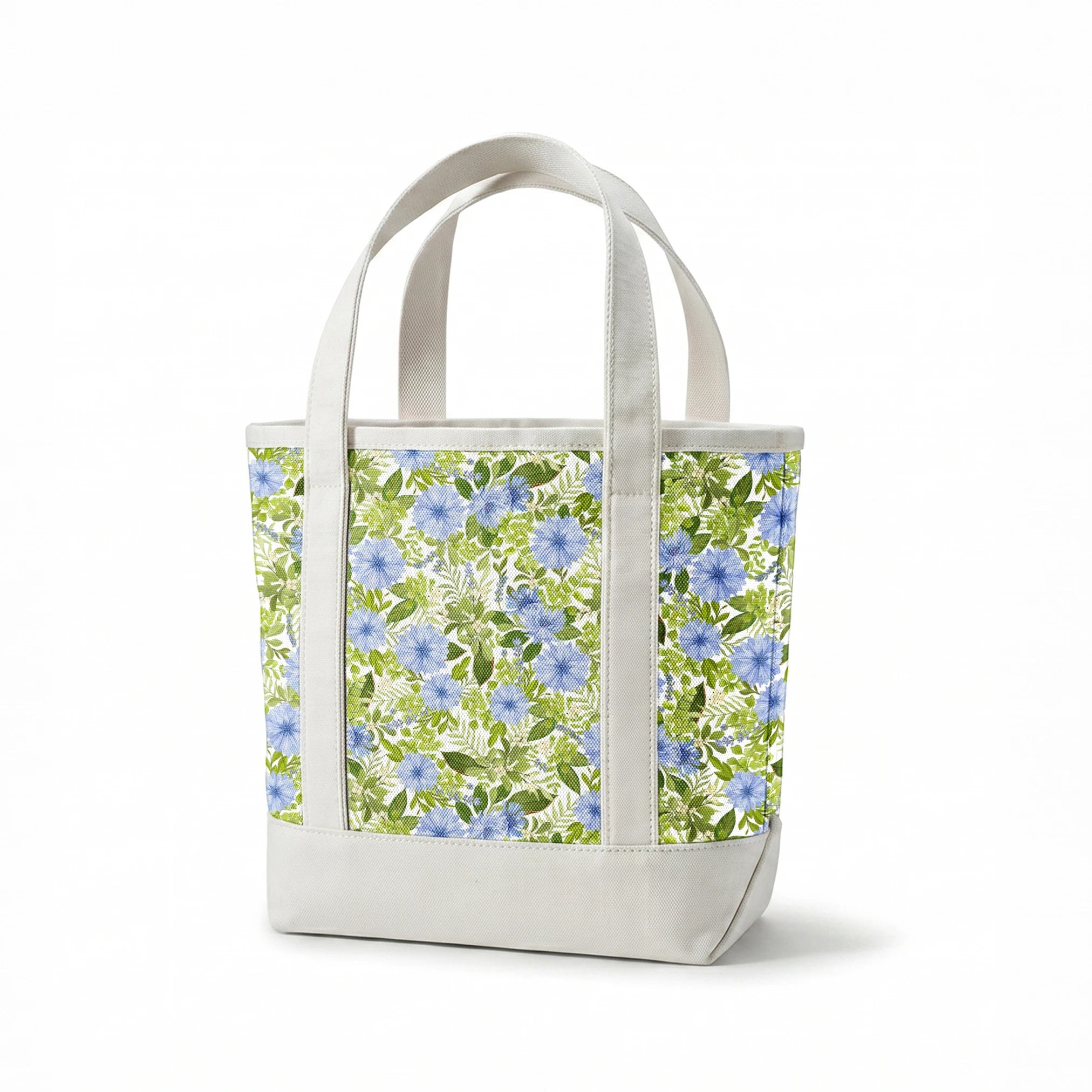 Watercolor-style botanical fabric pattern featuring blue wildflowers and soft green foliage on a white background. Designed by Nicole Tamarin. springs canvastote mockup