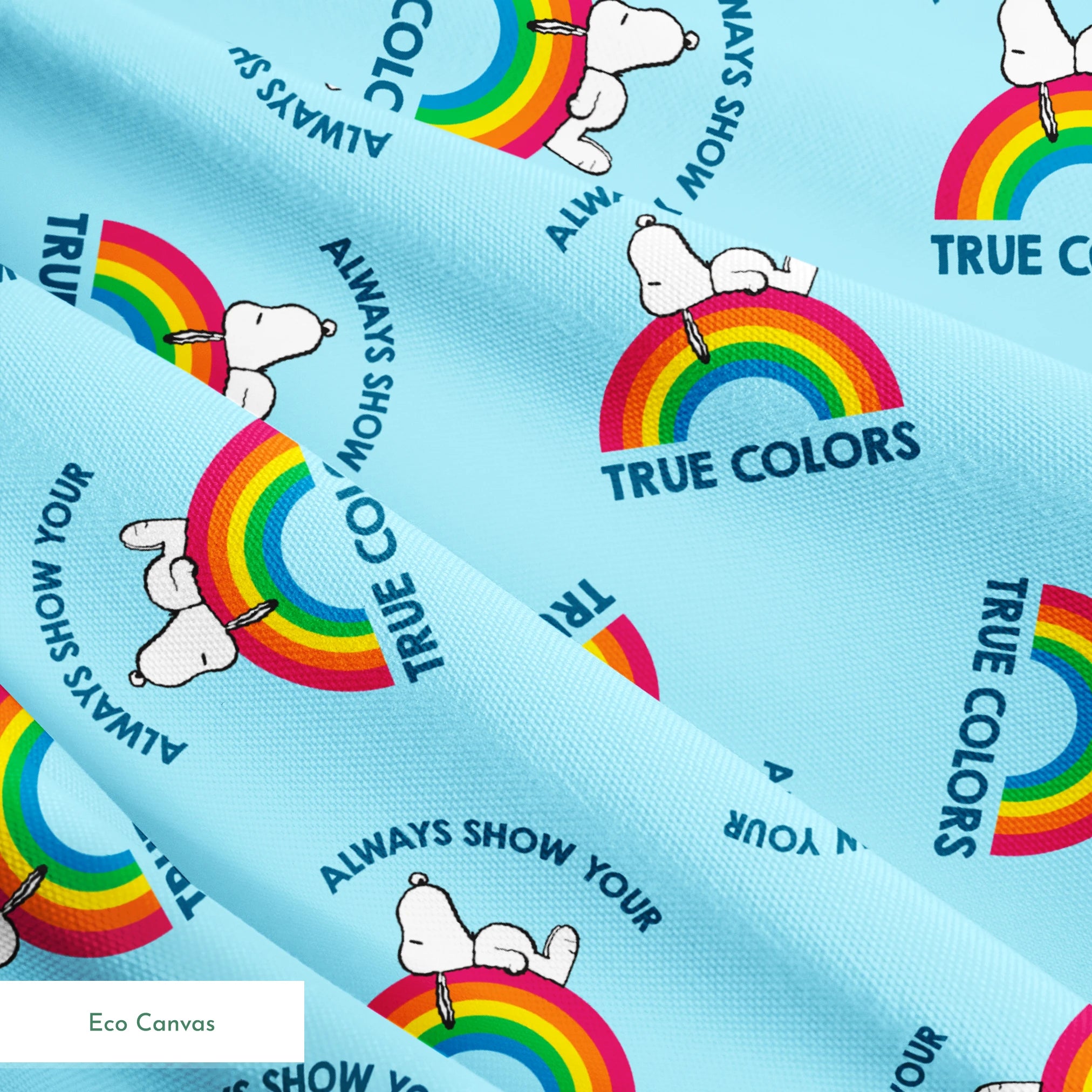 Rainbow Snoopy pattern on light blue background with white clouds and "TRUE COLORS" and "ALWAYS SHOW YOUR" text repeated throughout design springs ecocanvas texture