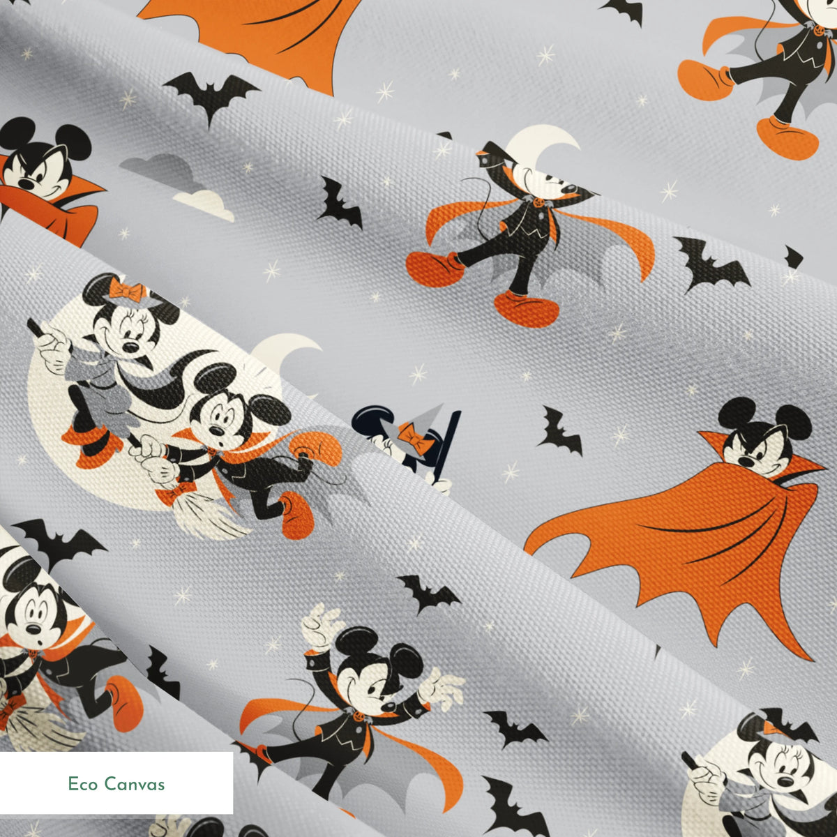 Mickey and Minnie Mouse in Halloween costumes on gray background with bats and moons, orange capes and spooky theme. springs ecocanvas texture