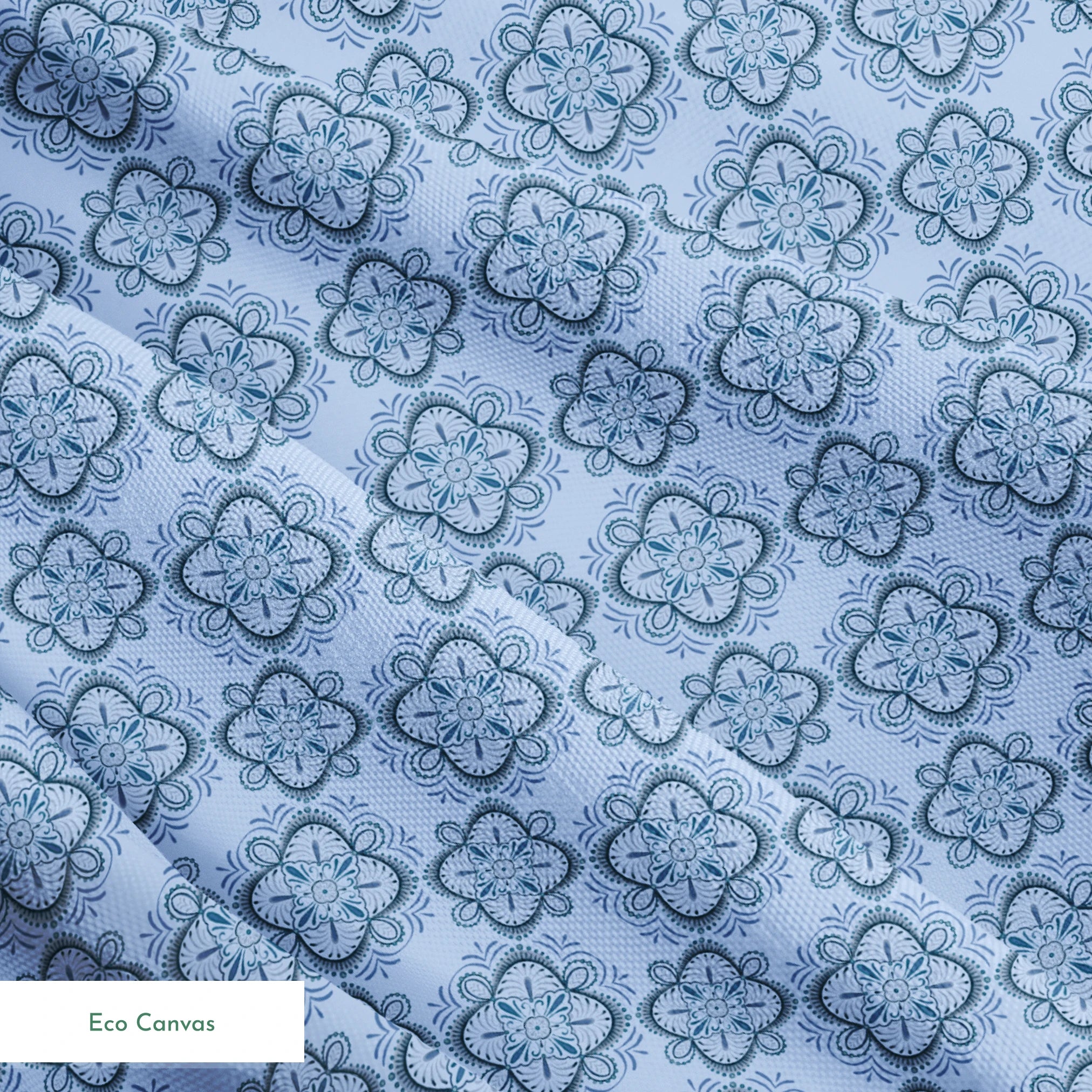 Symmetrical floral mandala pattern in layered blue tones with hand-drawn botanical details, designed by Nicole Tamarin. springs ecocanvas texture