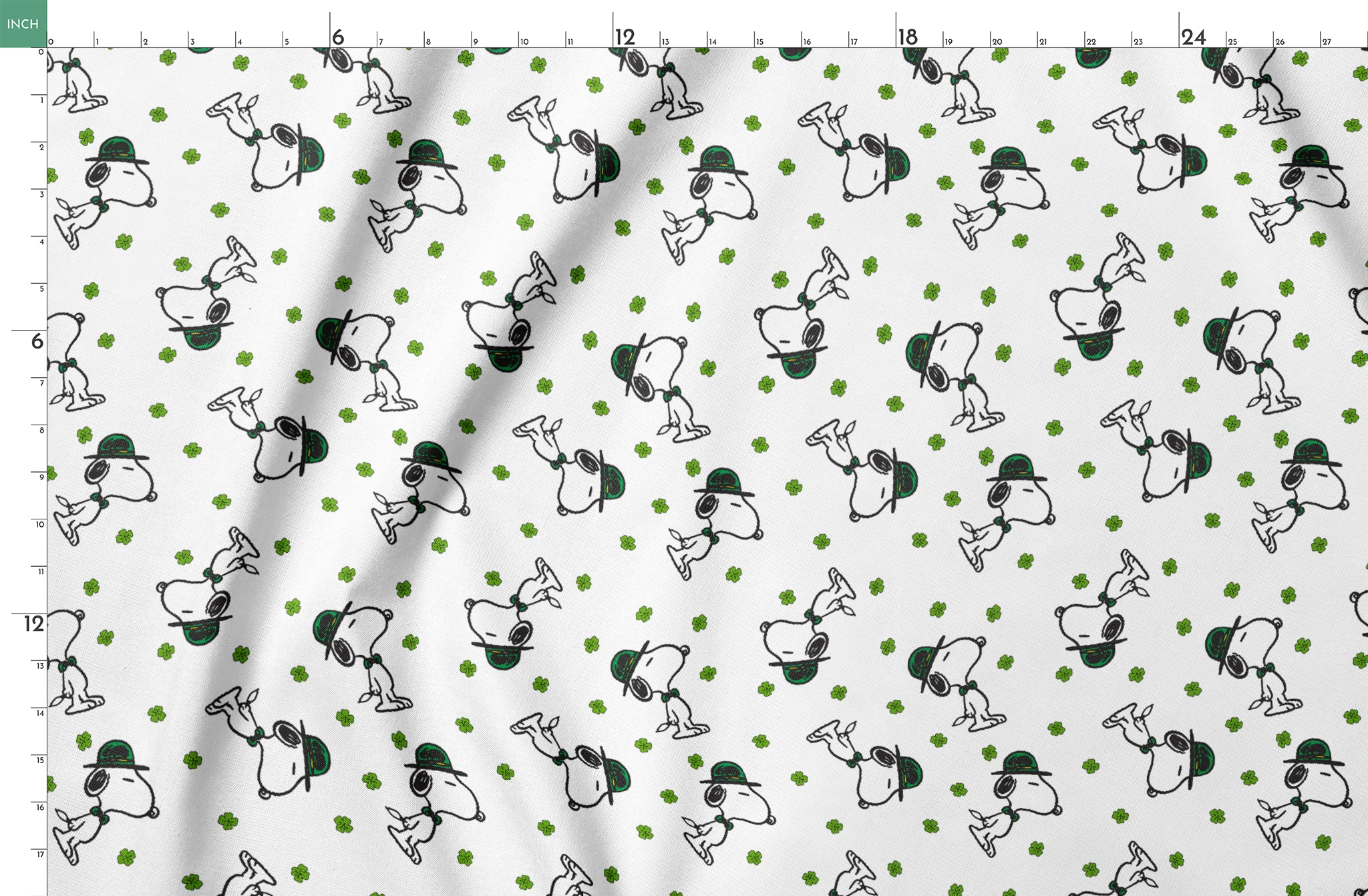 Cartoon Snoopy wearing green hat with shamrocks scattered across white background springs fatquarter mockup
